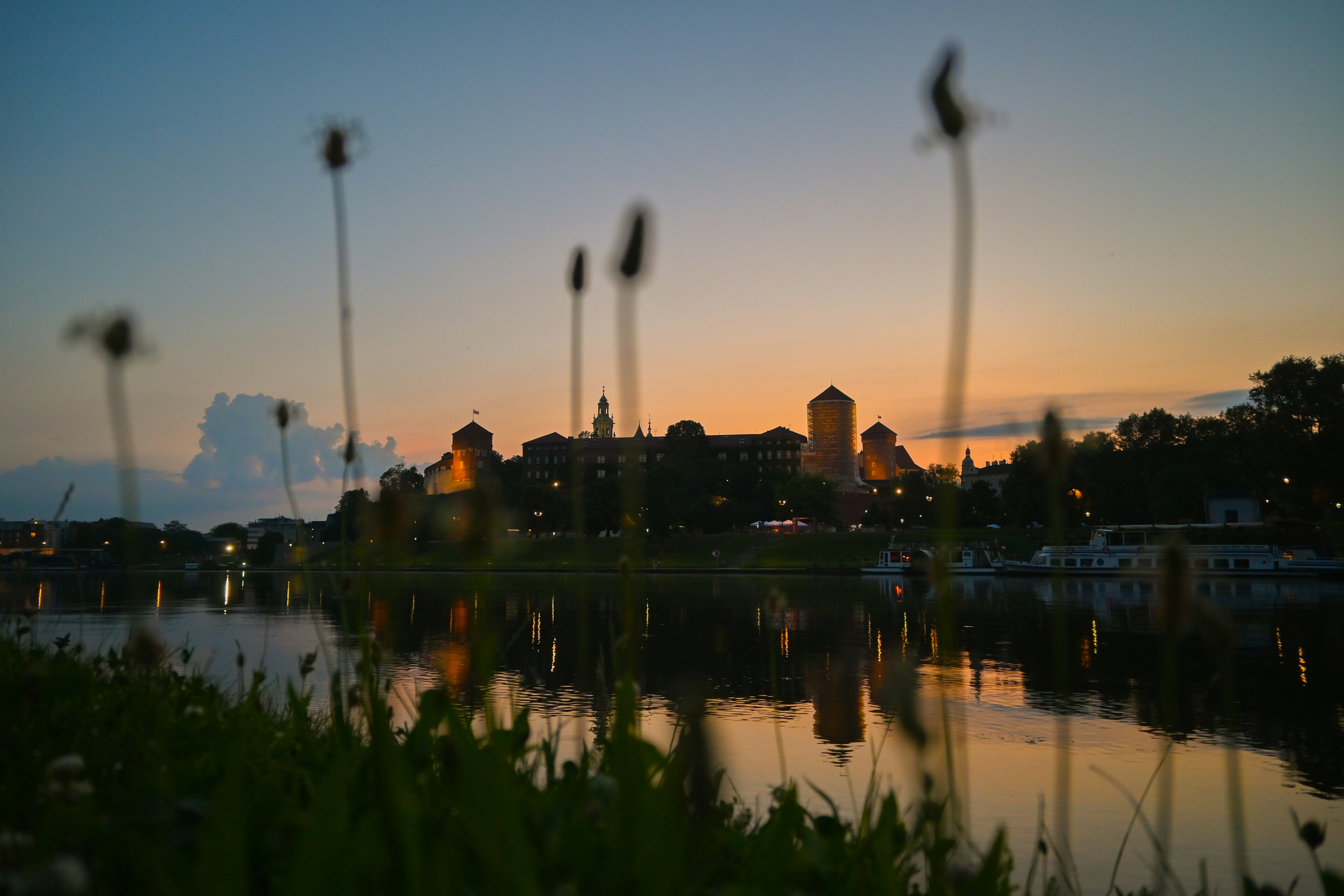 Wawel Castle silhouette across the Vistula River in Kraków at golden hour