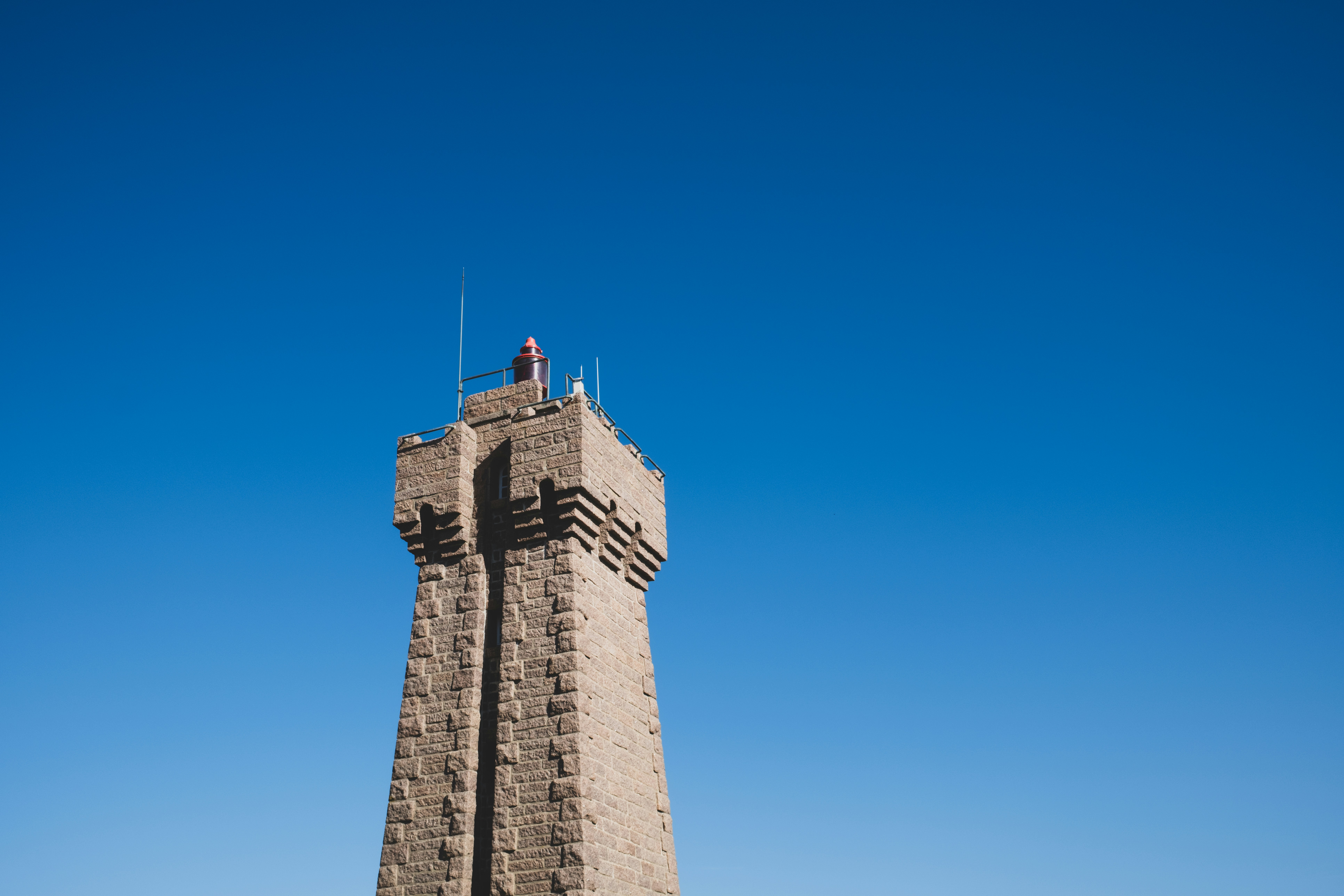 Uma torre de farol de pedra contra um céu azul claro