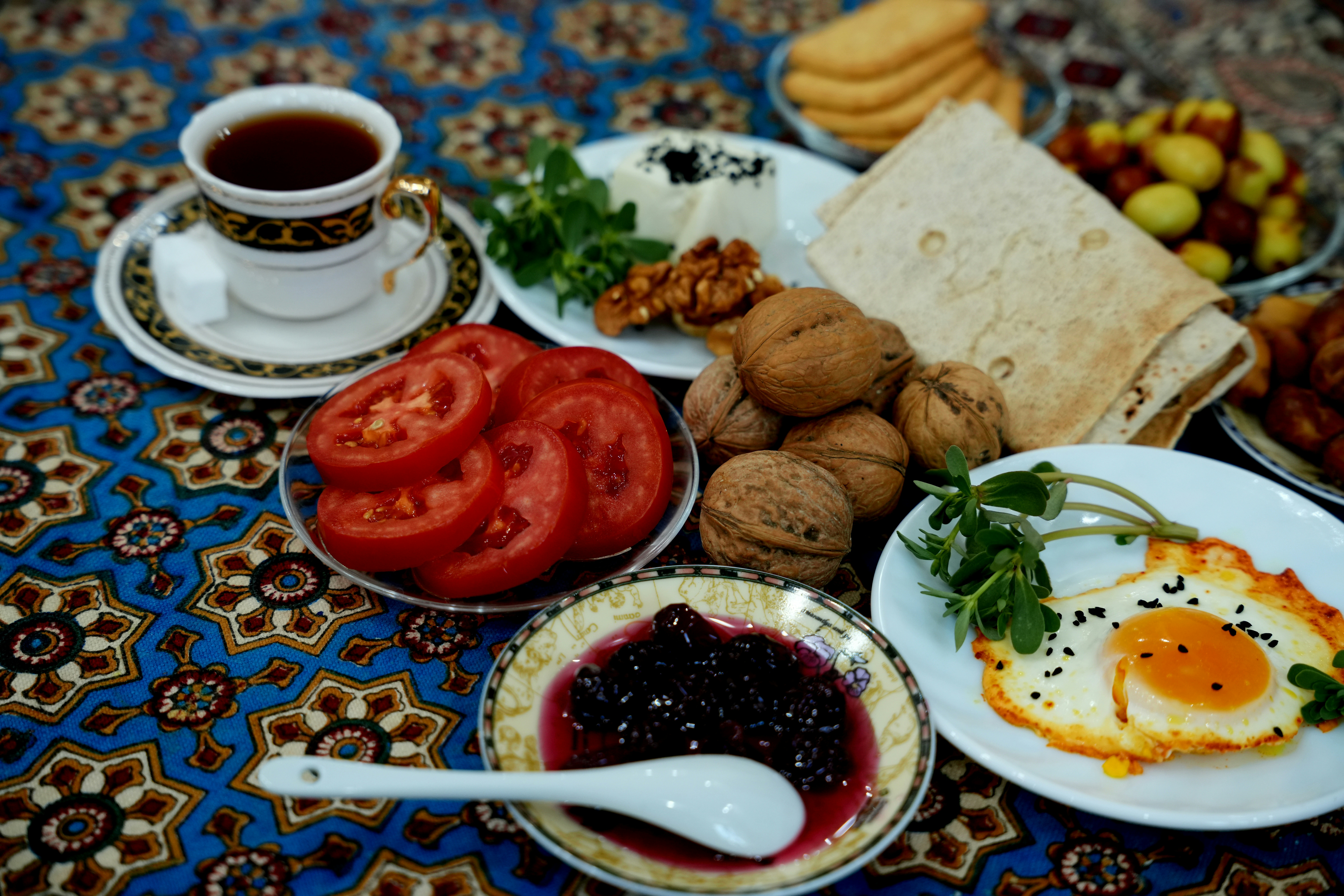 Breakfast spread with eggs, tomatoes, jam and tea