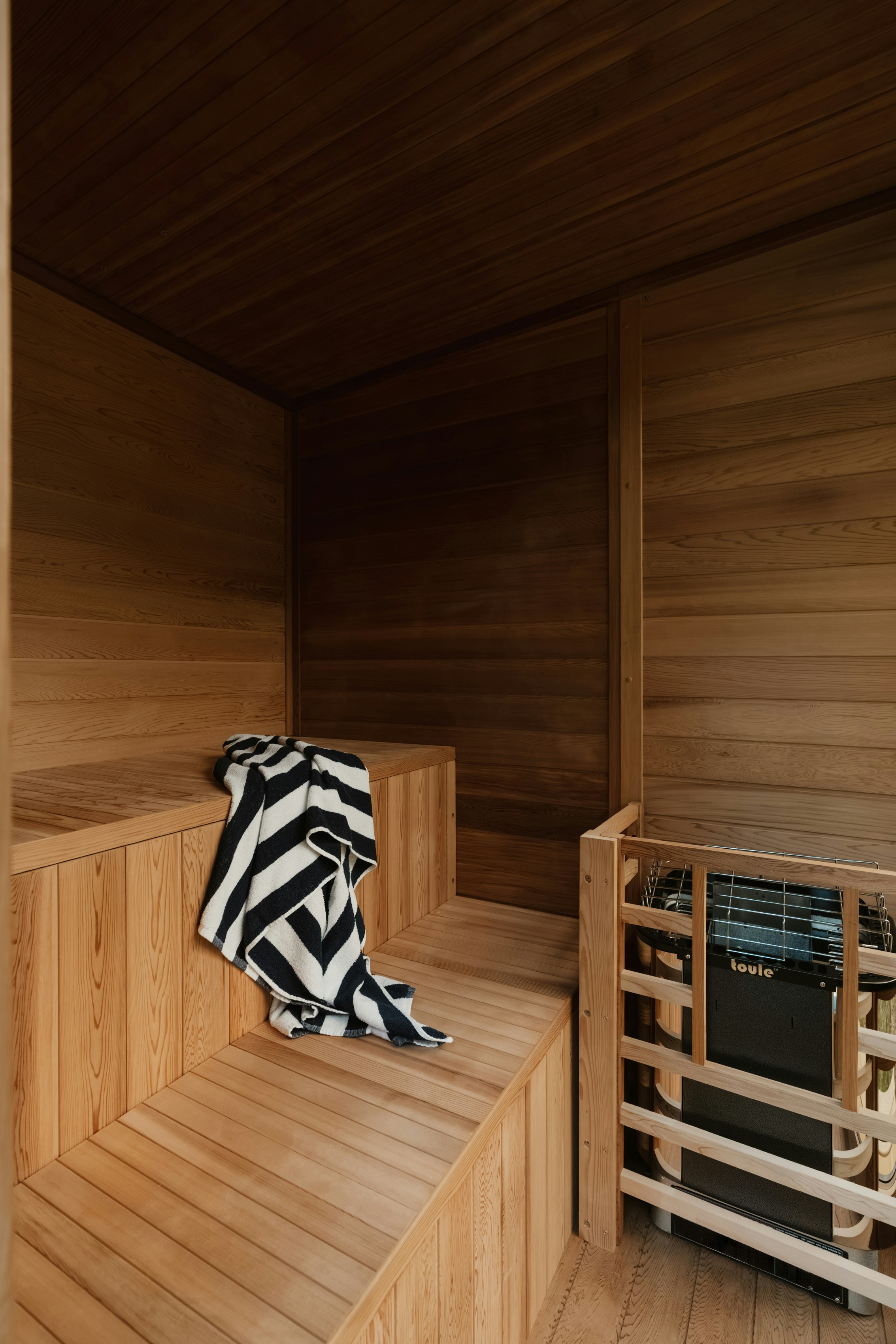 A black and white striped towel on a wooden sauna bench