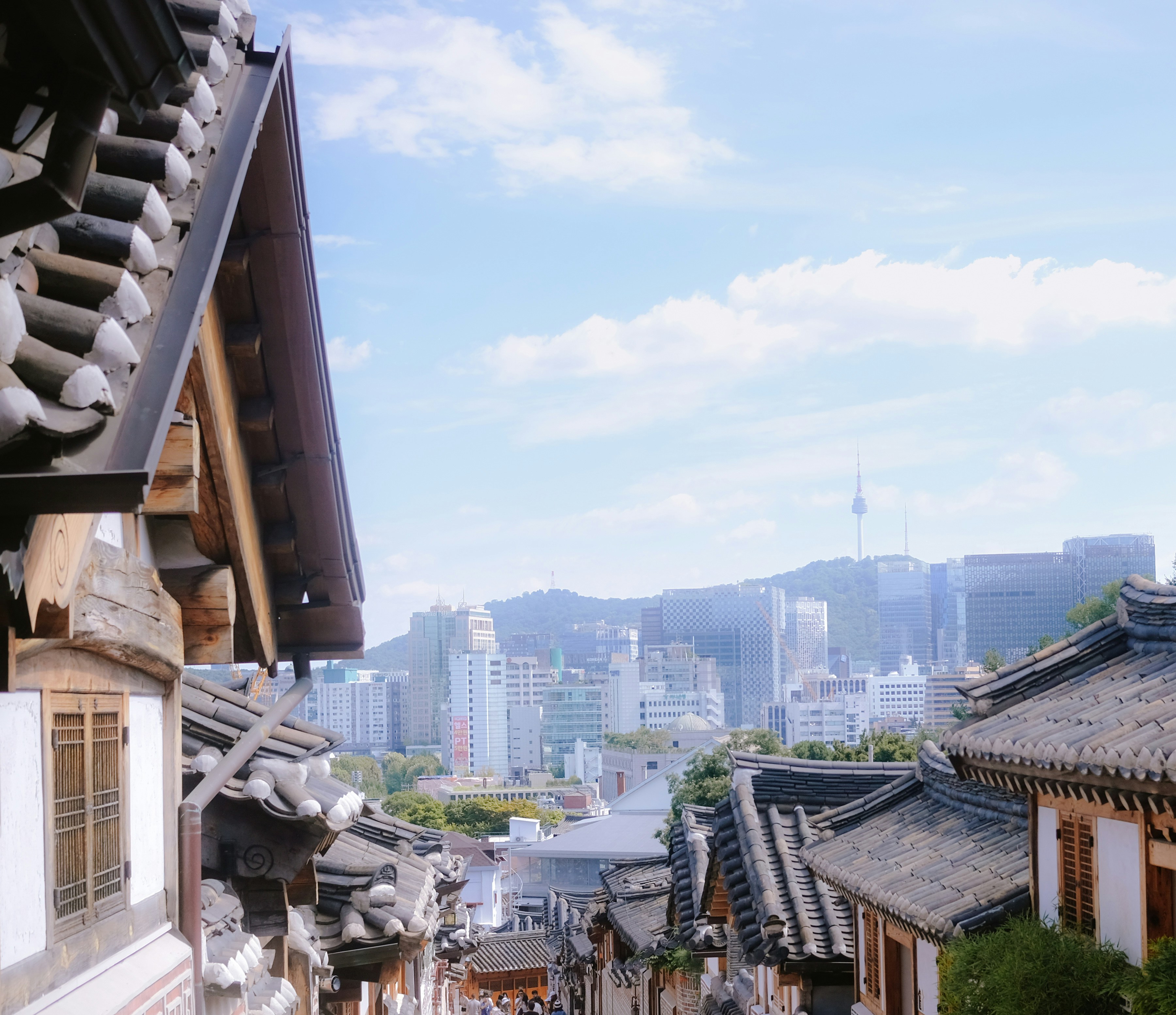 Krovovi tradicionalnih kuća hanok ispred modernih zgrada i tornja N Seoul Tower u Seulu