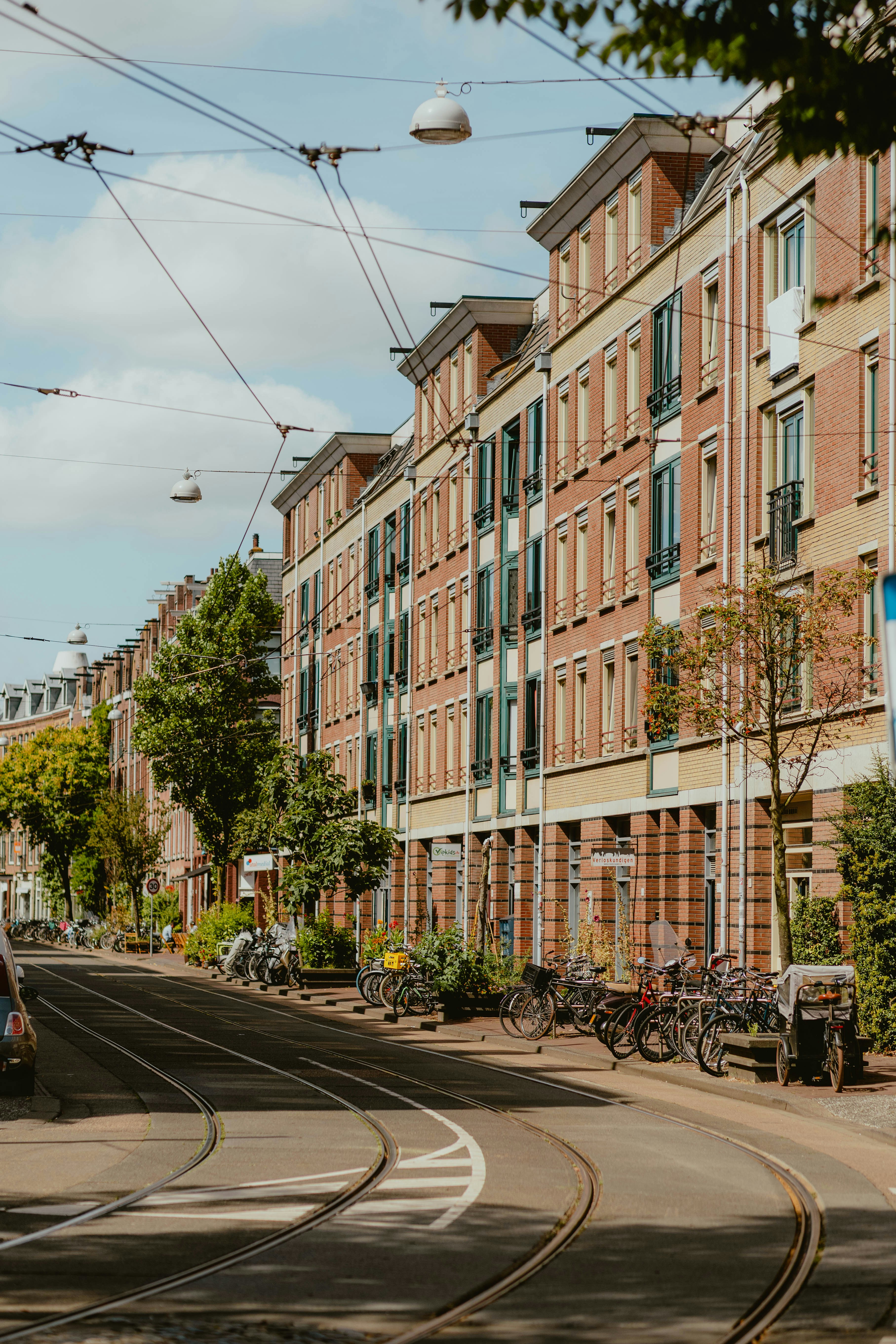 Tram tracks running along a street with brick apartment buildings and parked bicycles - 相关推荐