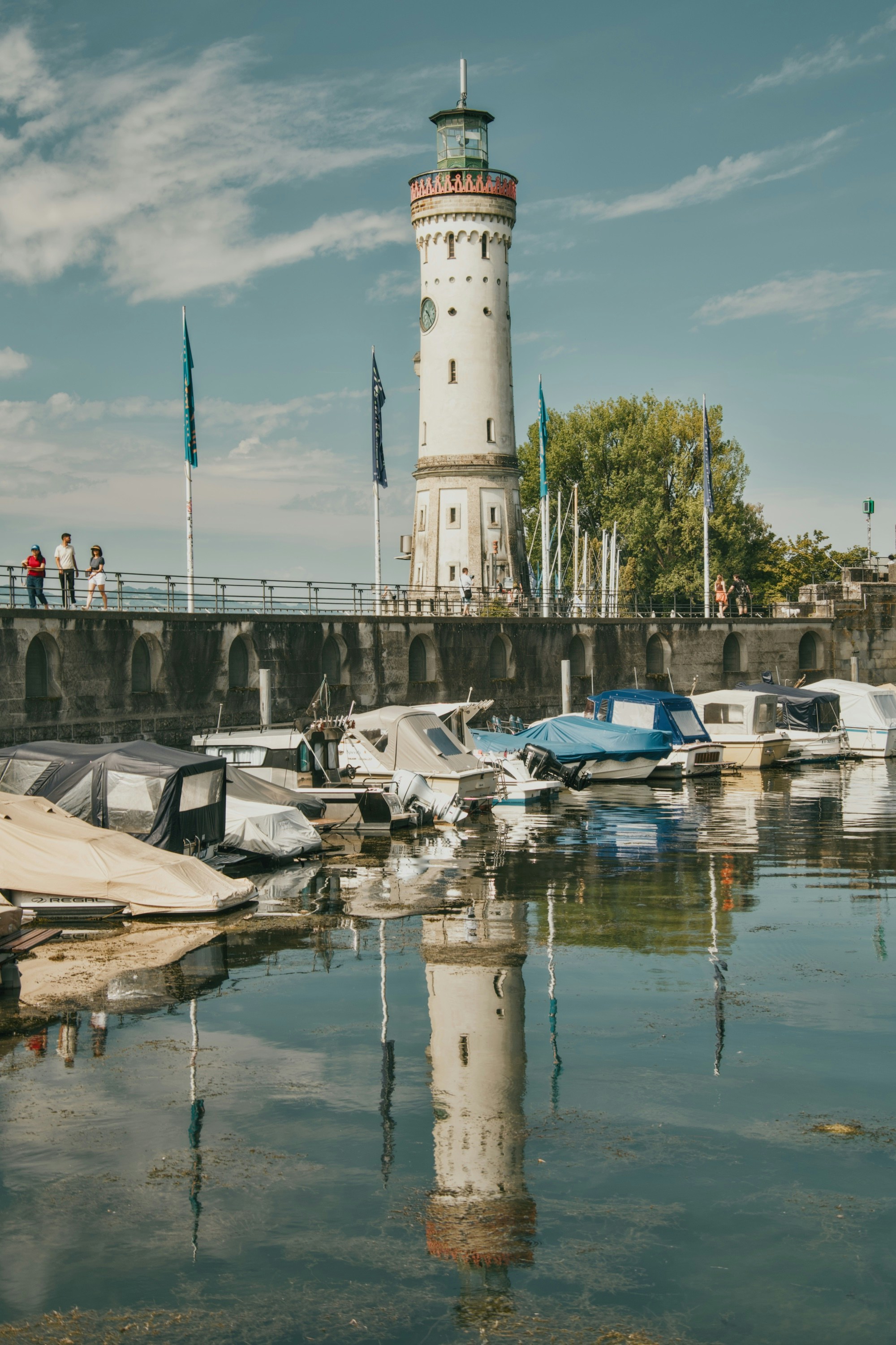 Il faro di Mangturm che si riflette nelle calme acque del porto di Lindau, Germania