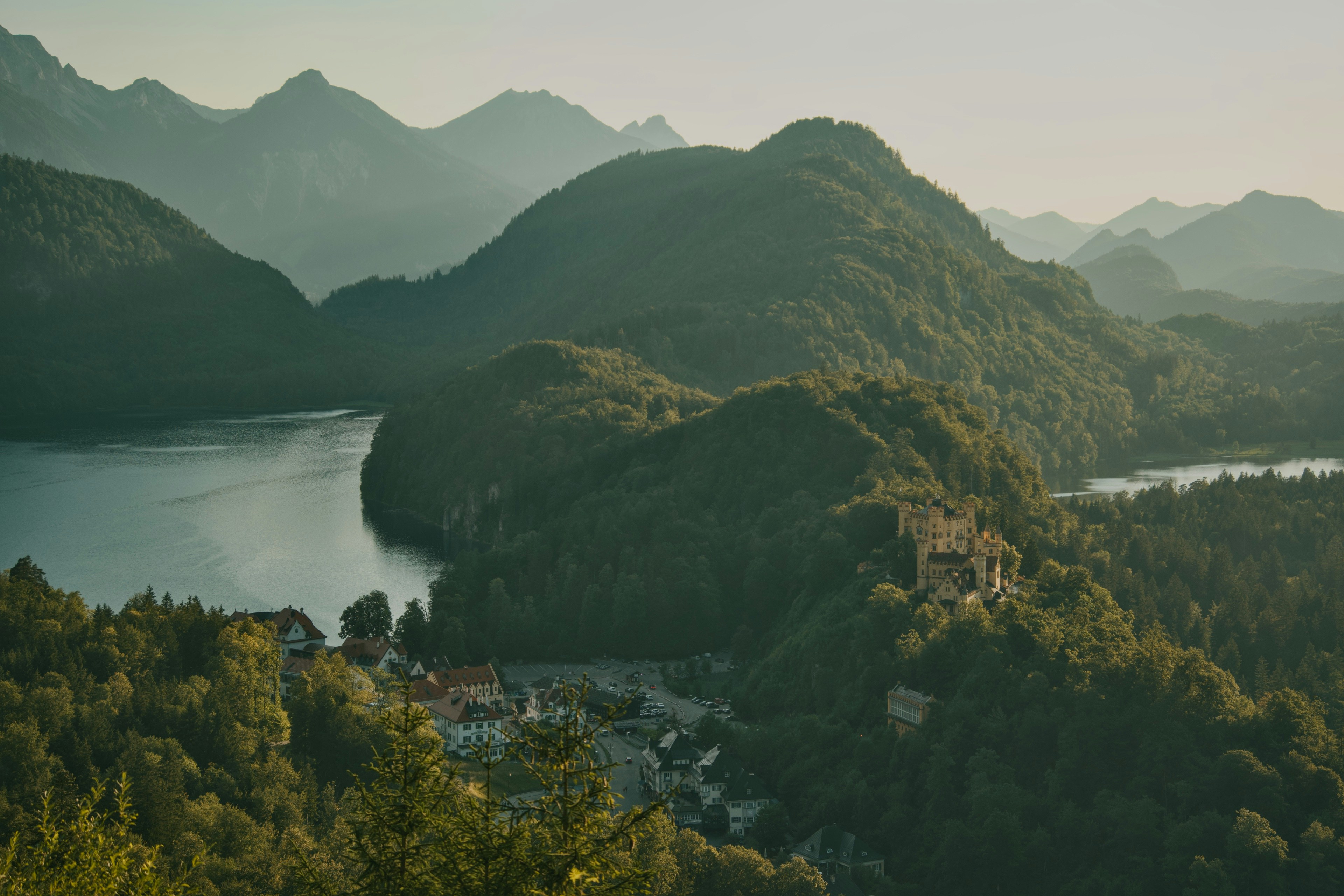 Castello di Hohenschwangau su una collina boscosa sopra un lago nelle Alpi Bavaresi