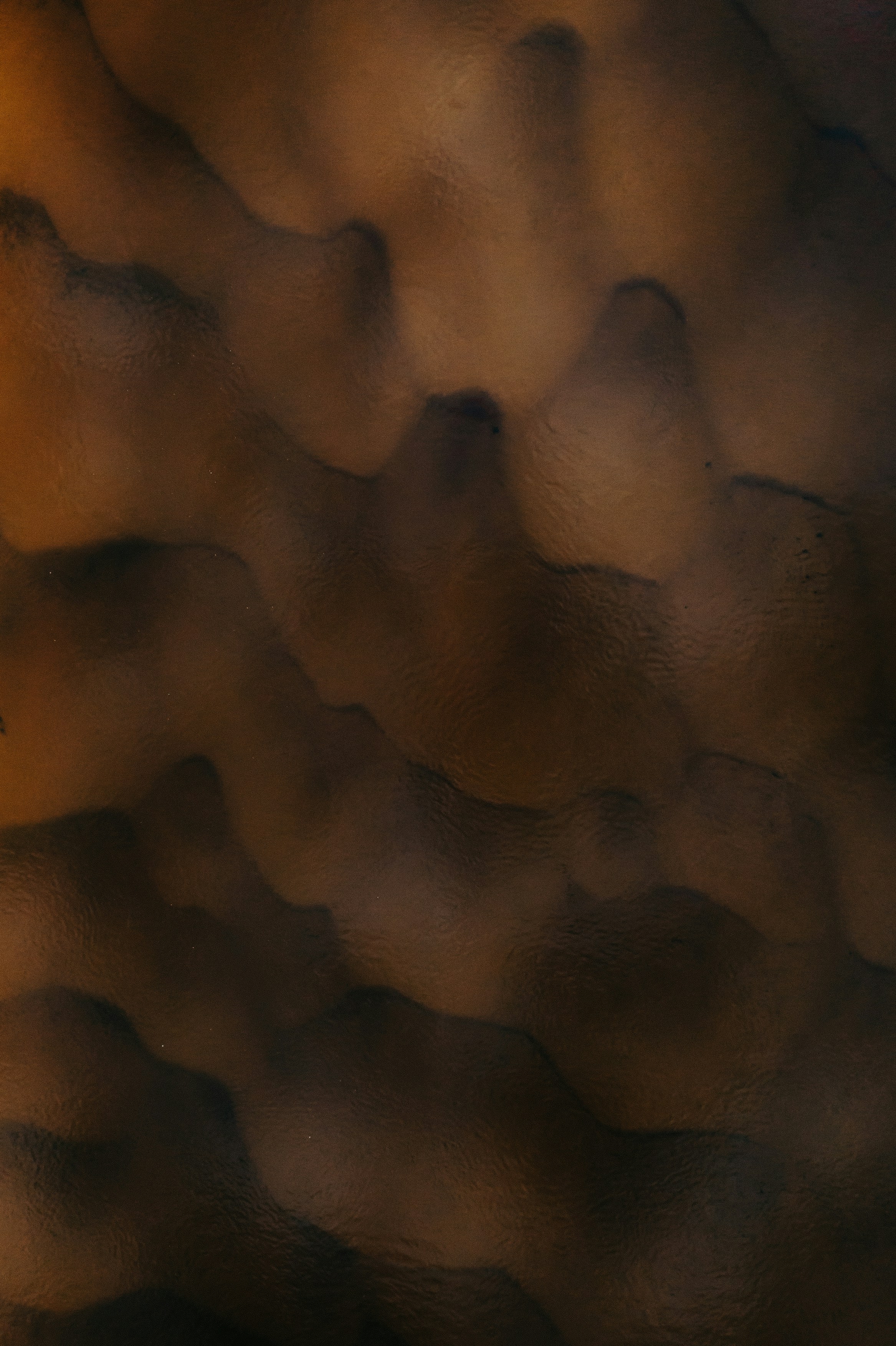 Abstract dark brown and black wavy patterns with a smooth liquid texture
