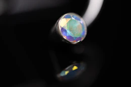 A macro view of an iridescent gemstone set in a silver metal stud
