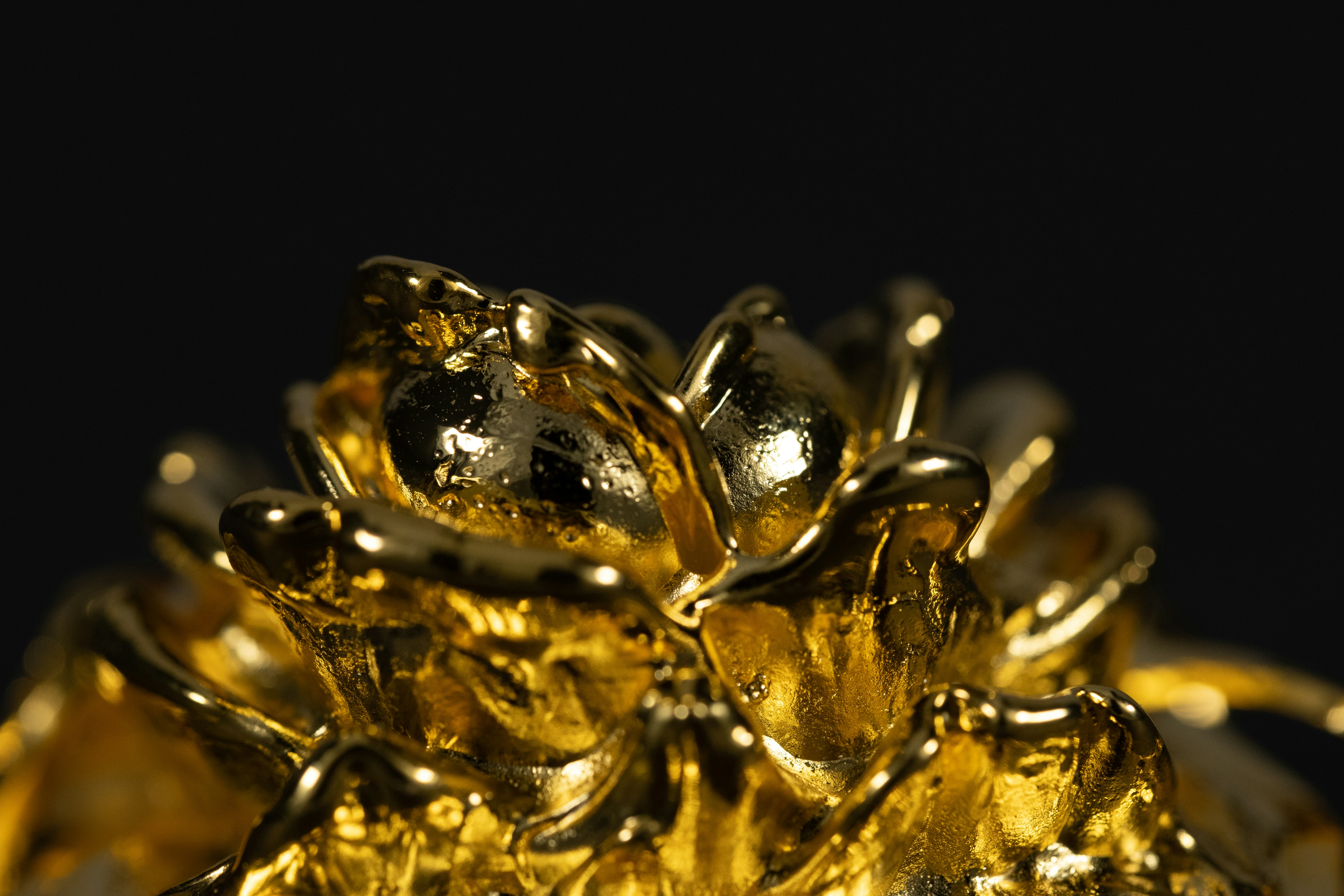A close-up shot of different gold forms: a shiny 24K gold bar, an intricately designed 22K gold necklace, and an elegant 18K gold ring with a diamond. Each item subtly shows its carat marking.