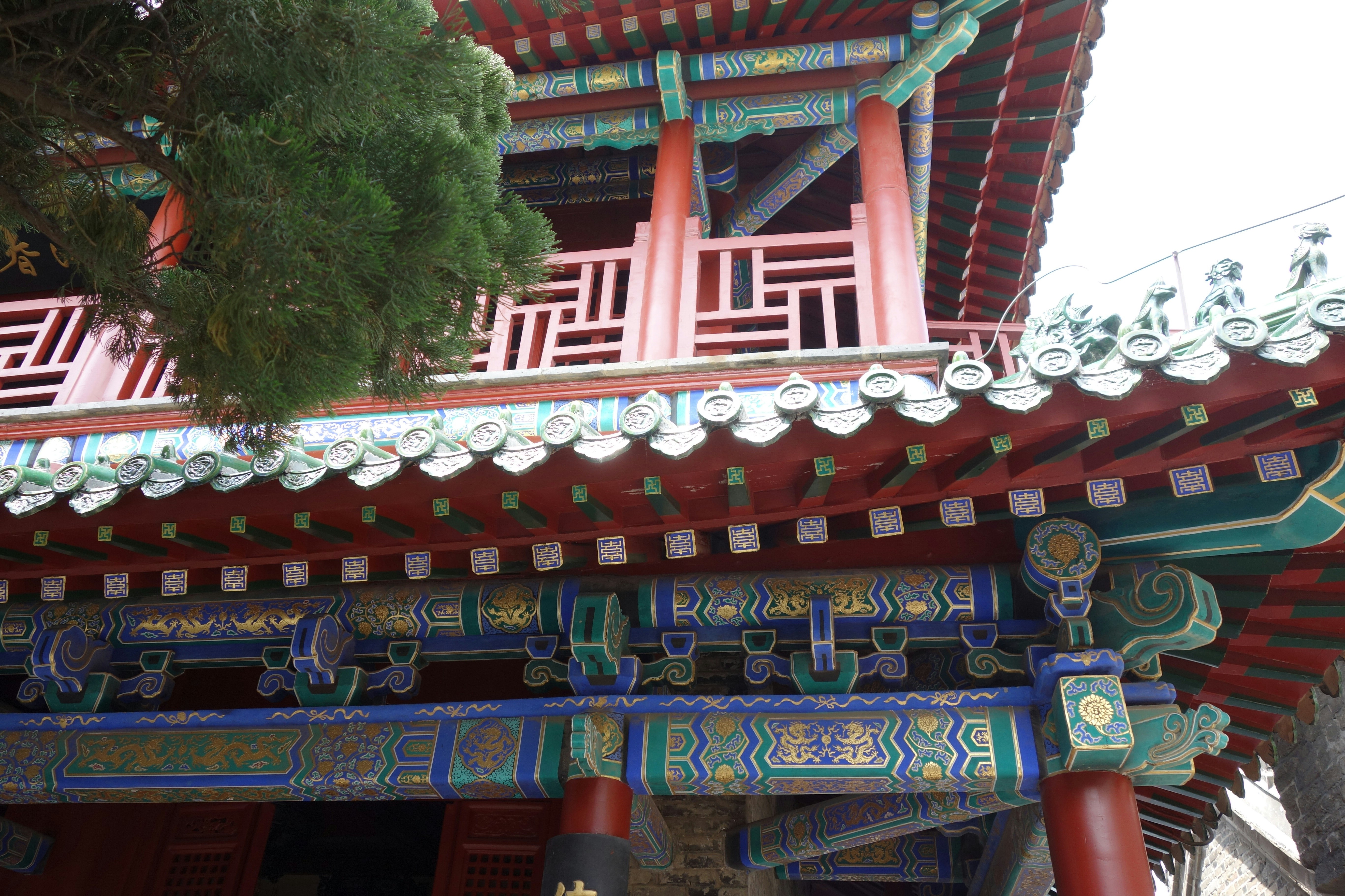 Ornate red and blue traditional Chinese architecture with intricate painted beams and tiled roof