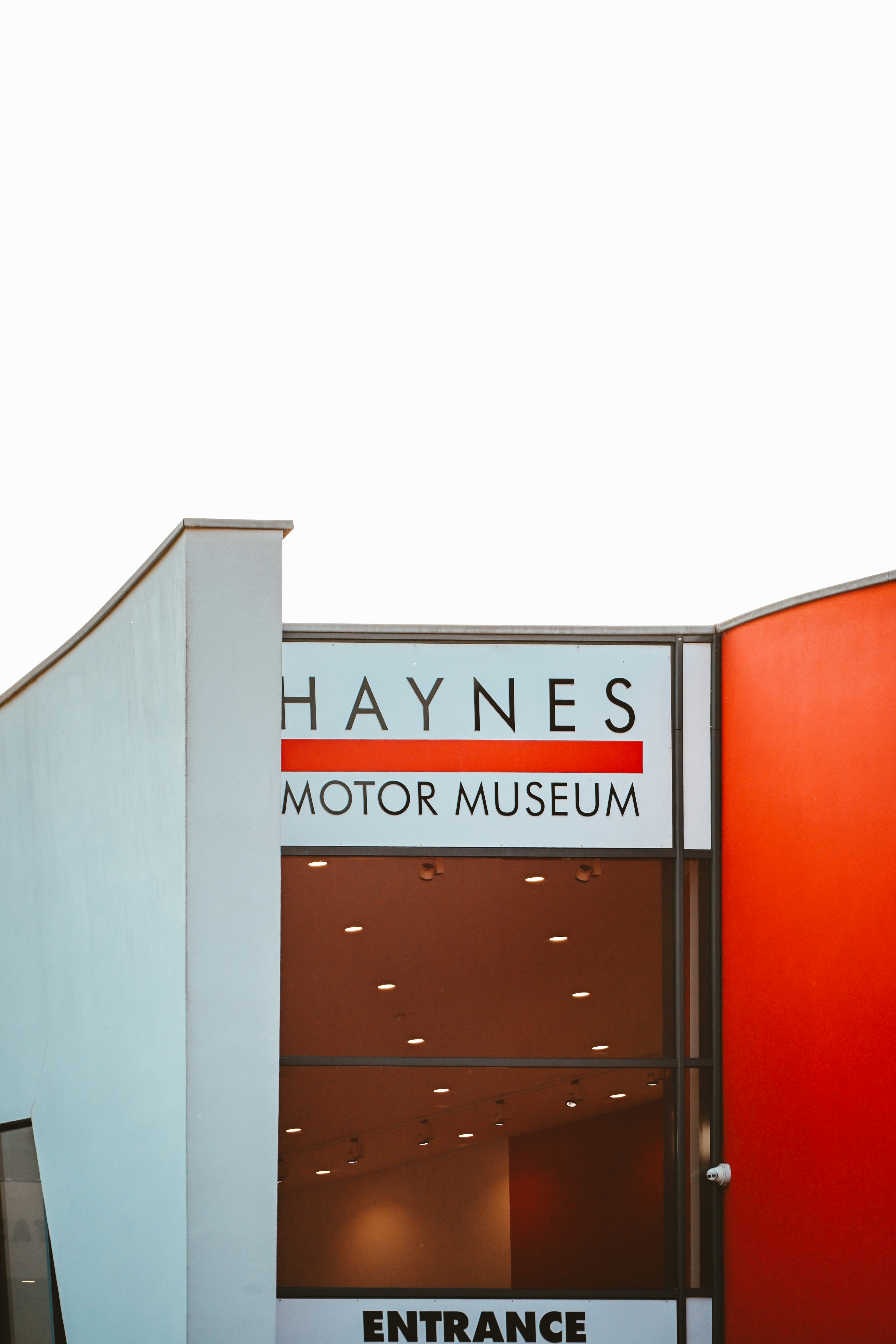 The Haynes Motor Museum entrance sign on a building with orange and grey walls