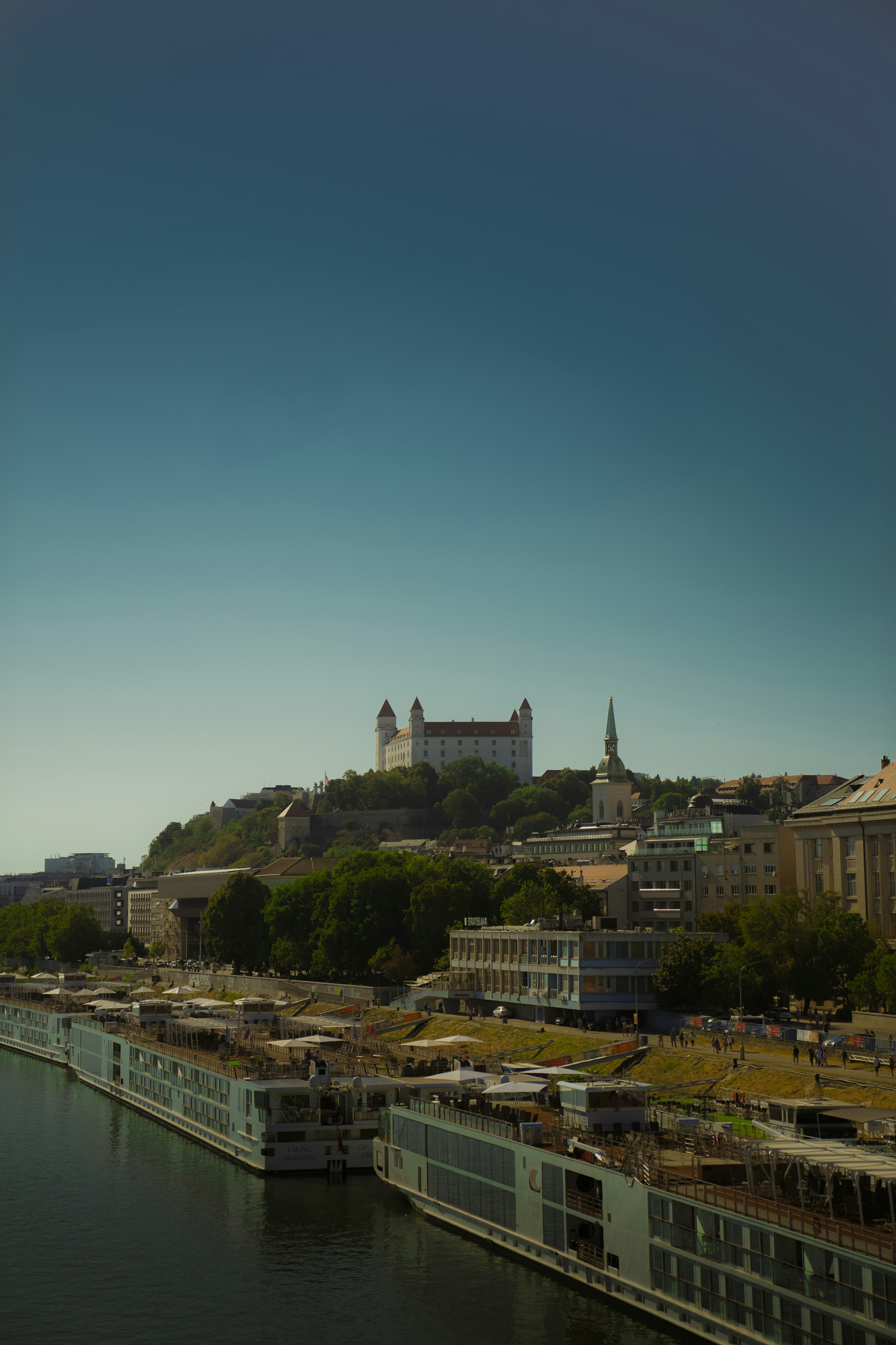 Bratislava Castle overlooking the Danube river with docked river cruise ships