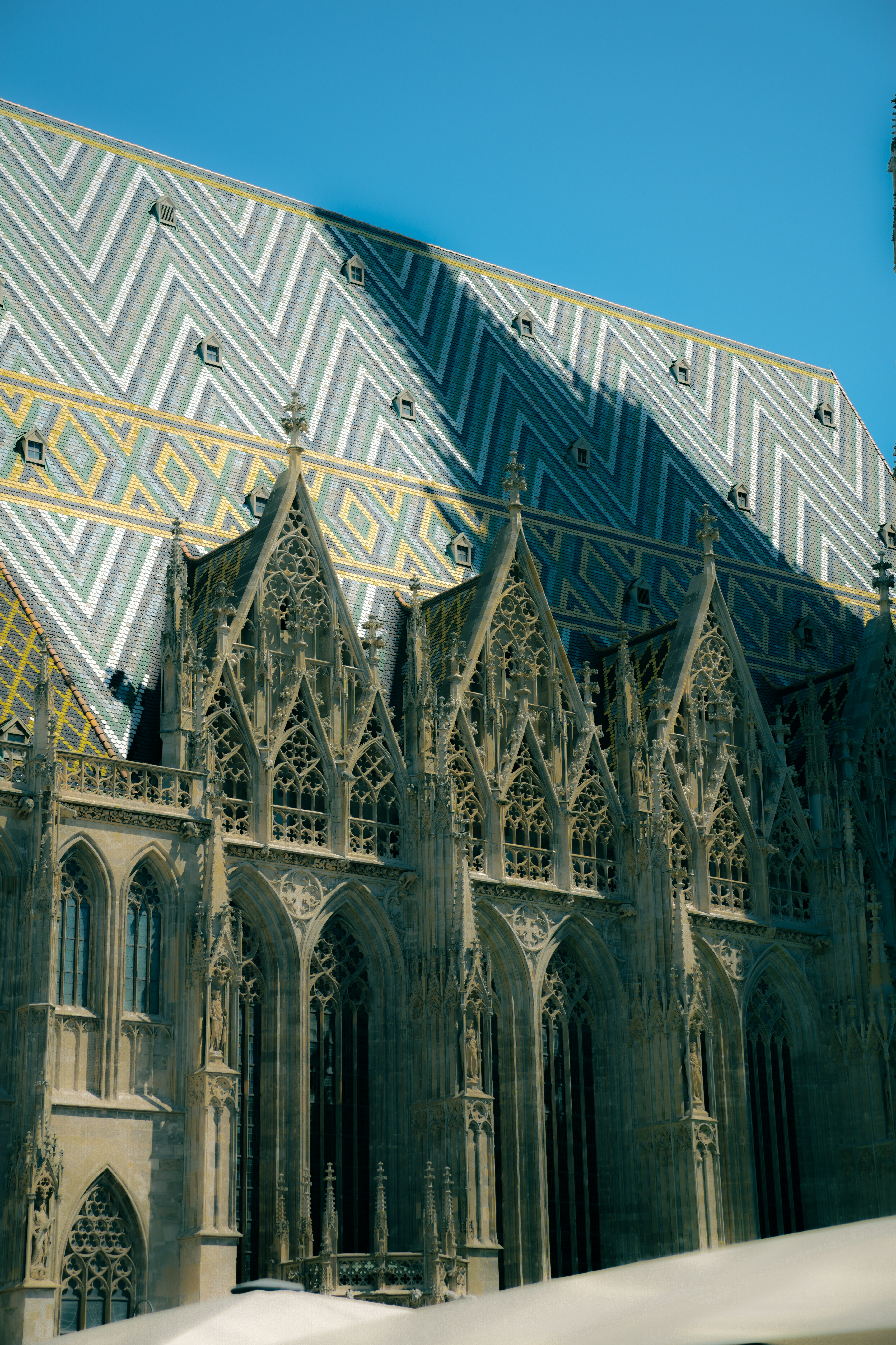 The patterned tiled roof and gothic stone facade of St. Stephen's Cathedral in Vienna