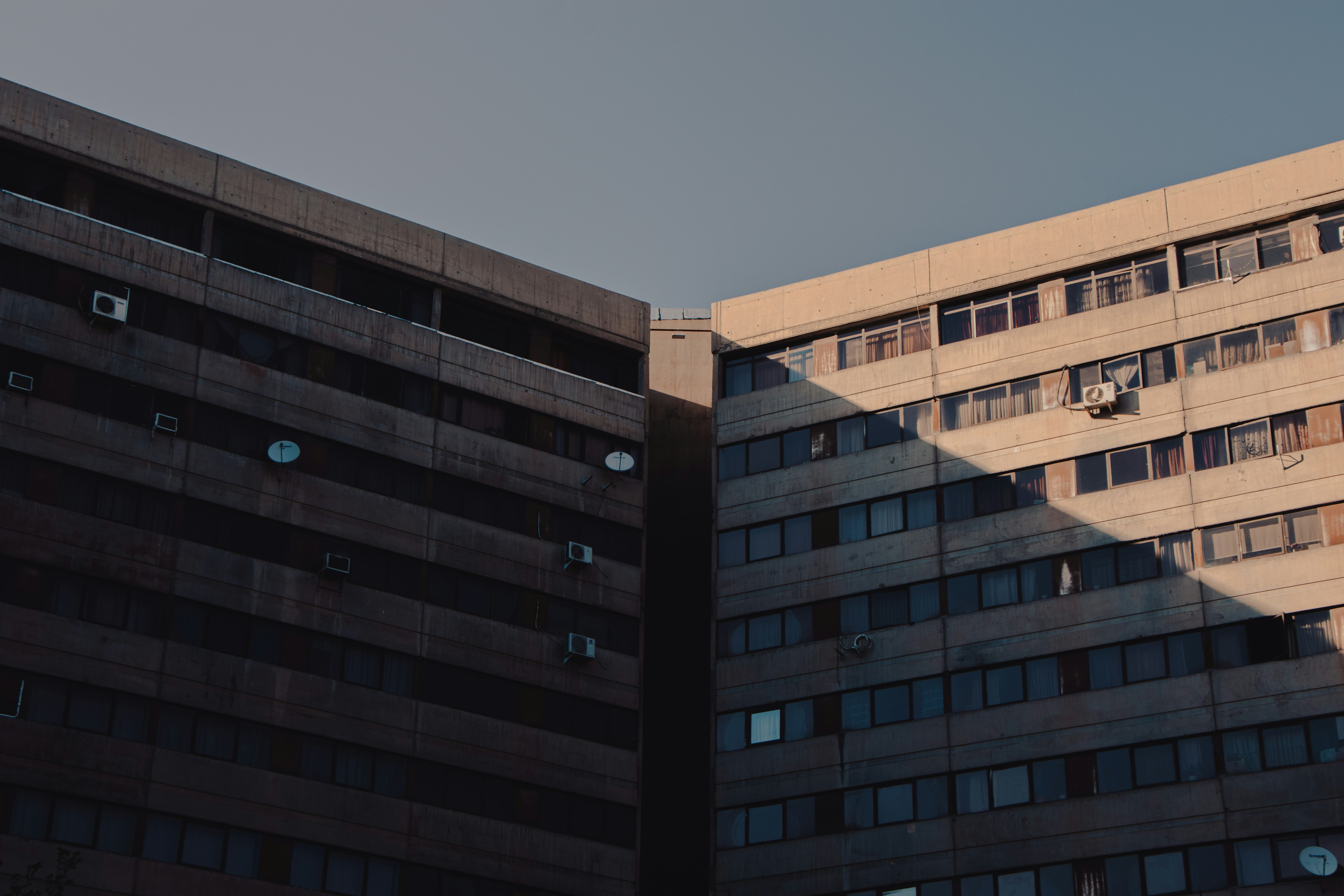 Dos edificios de apartamentos de hormigón se encuentran en ángulo bajo un cielo despejado