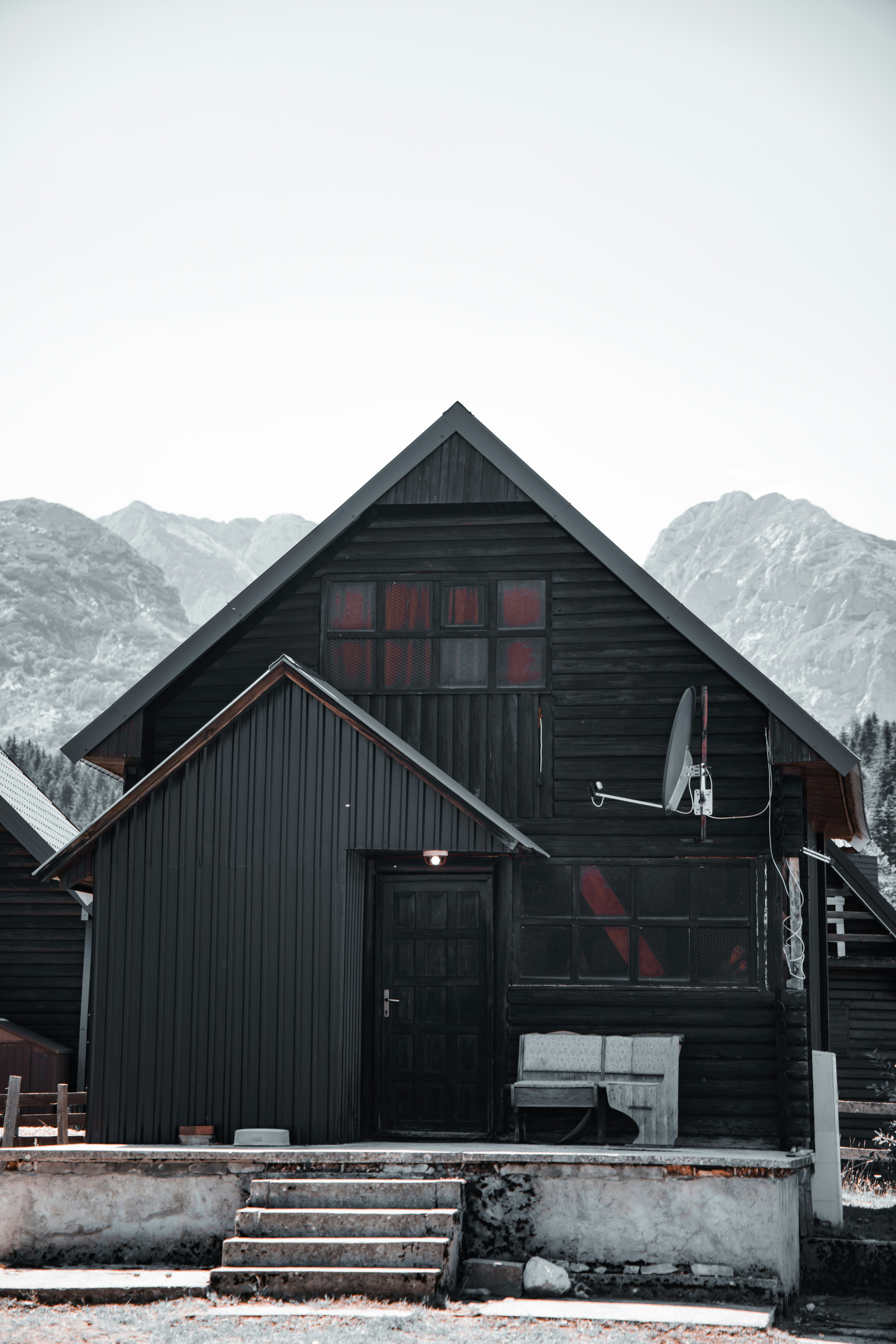 A dark timber chalet against an alpine ridge