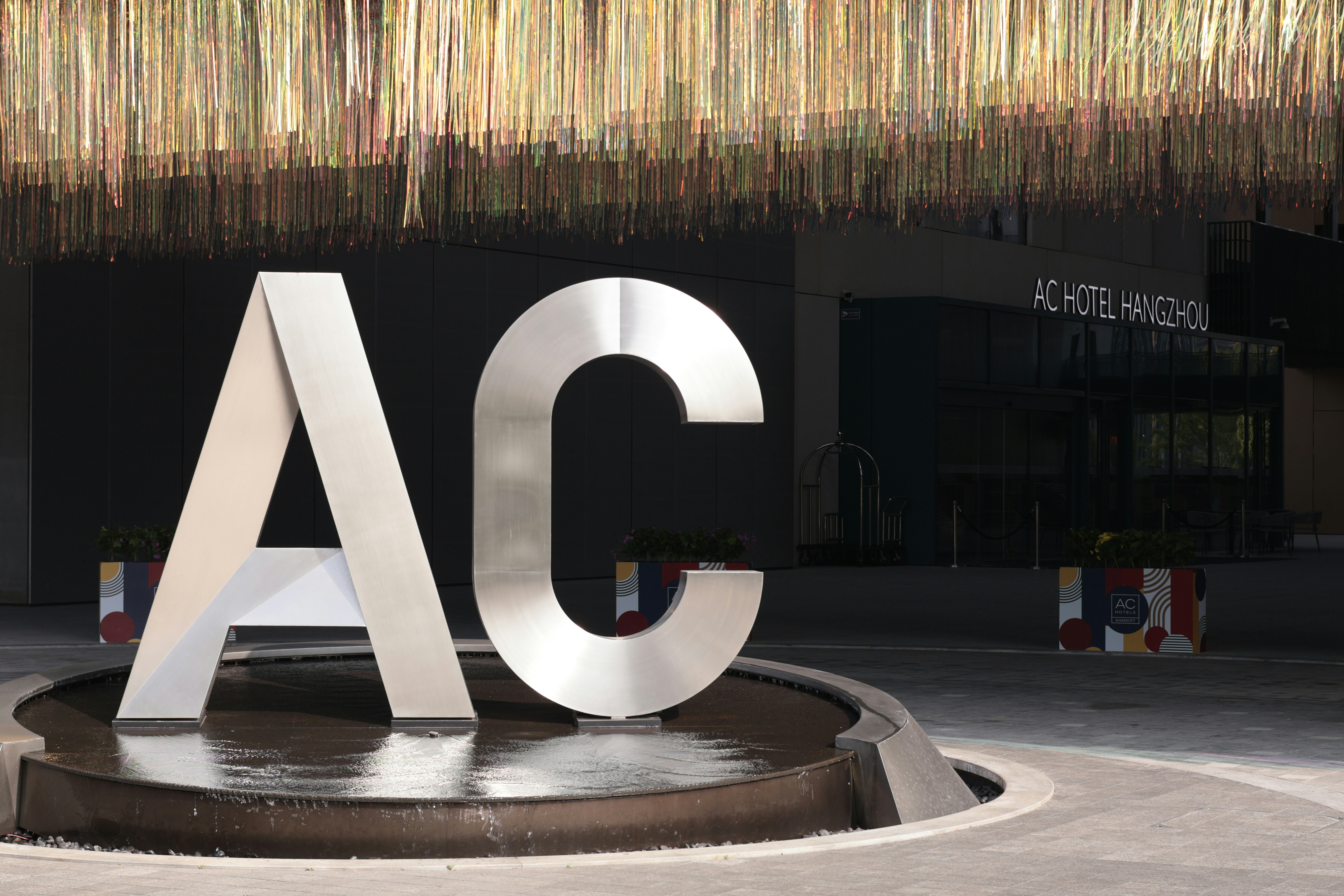 Large metal AC letters in a circular fountain outside the AC Hotel Hangzhou