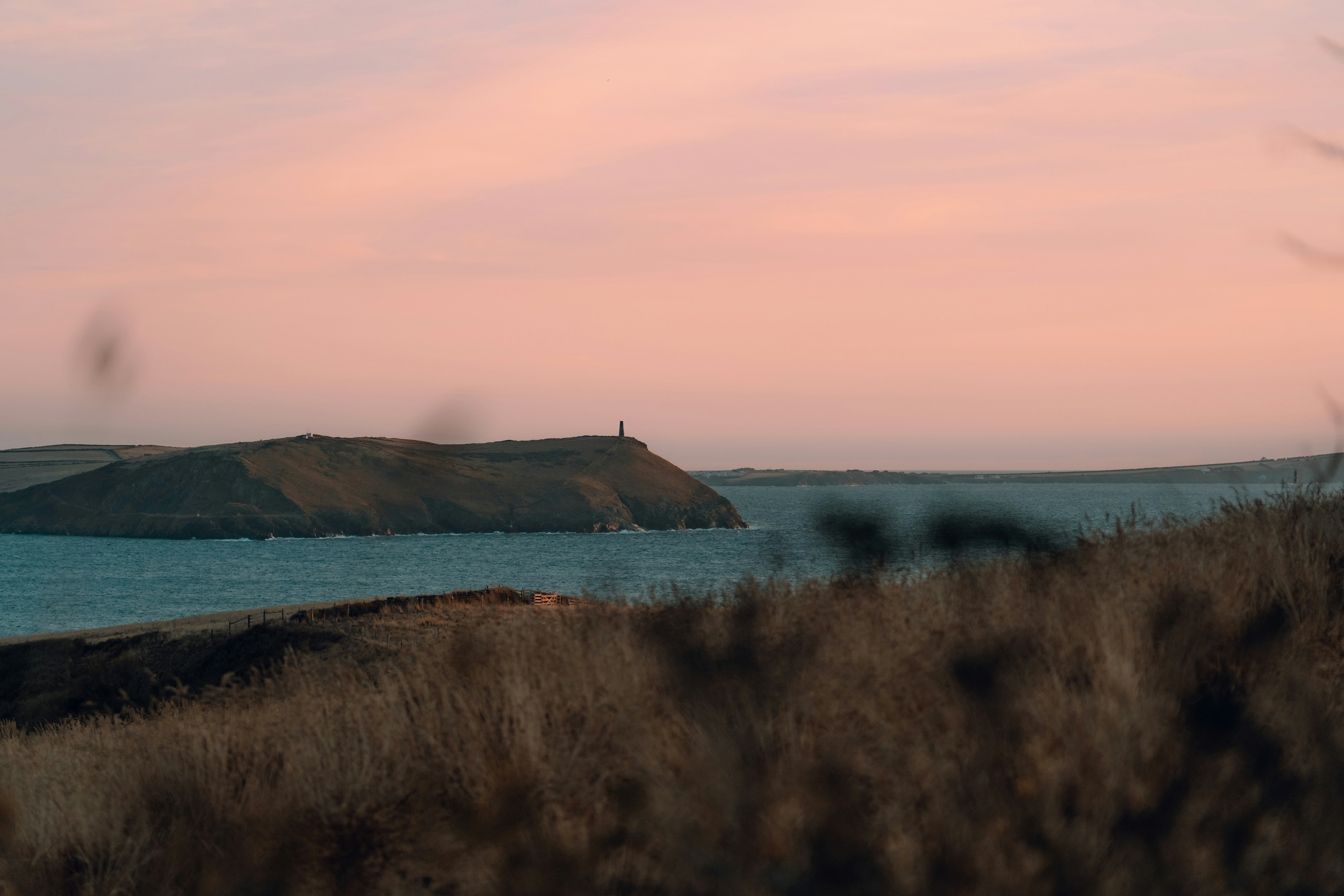 Küstenlandschaft mit Leuchtturm bei Sonnenuntergang