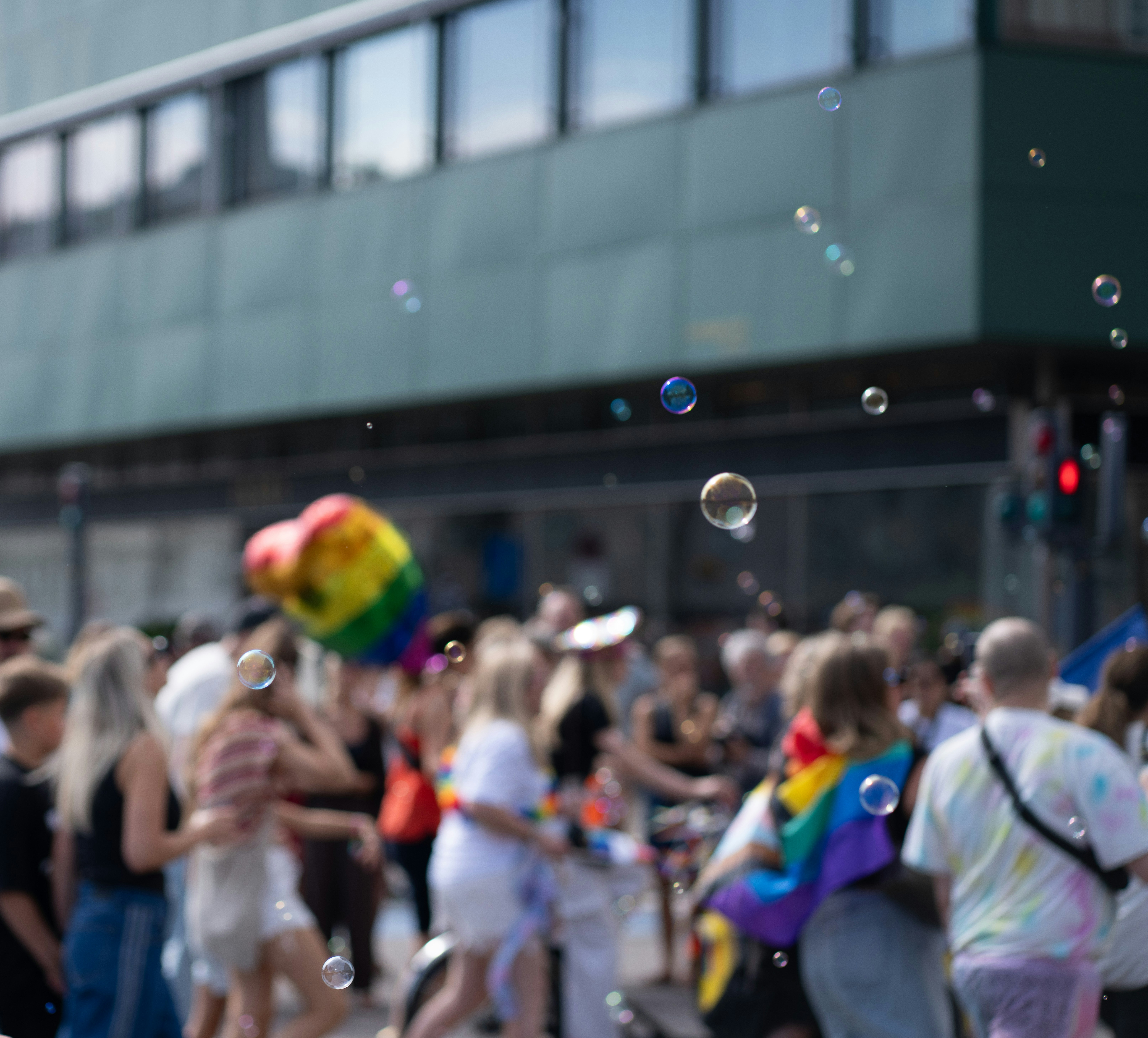 Des bulles flottant au-dessus d’une foule lors d’un défilé des fiertés