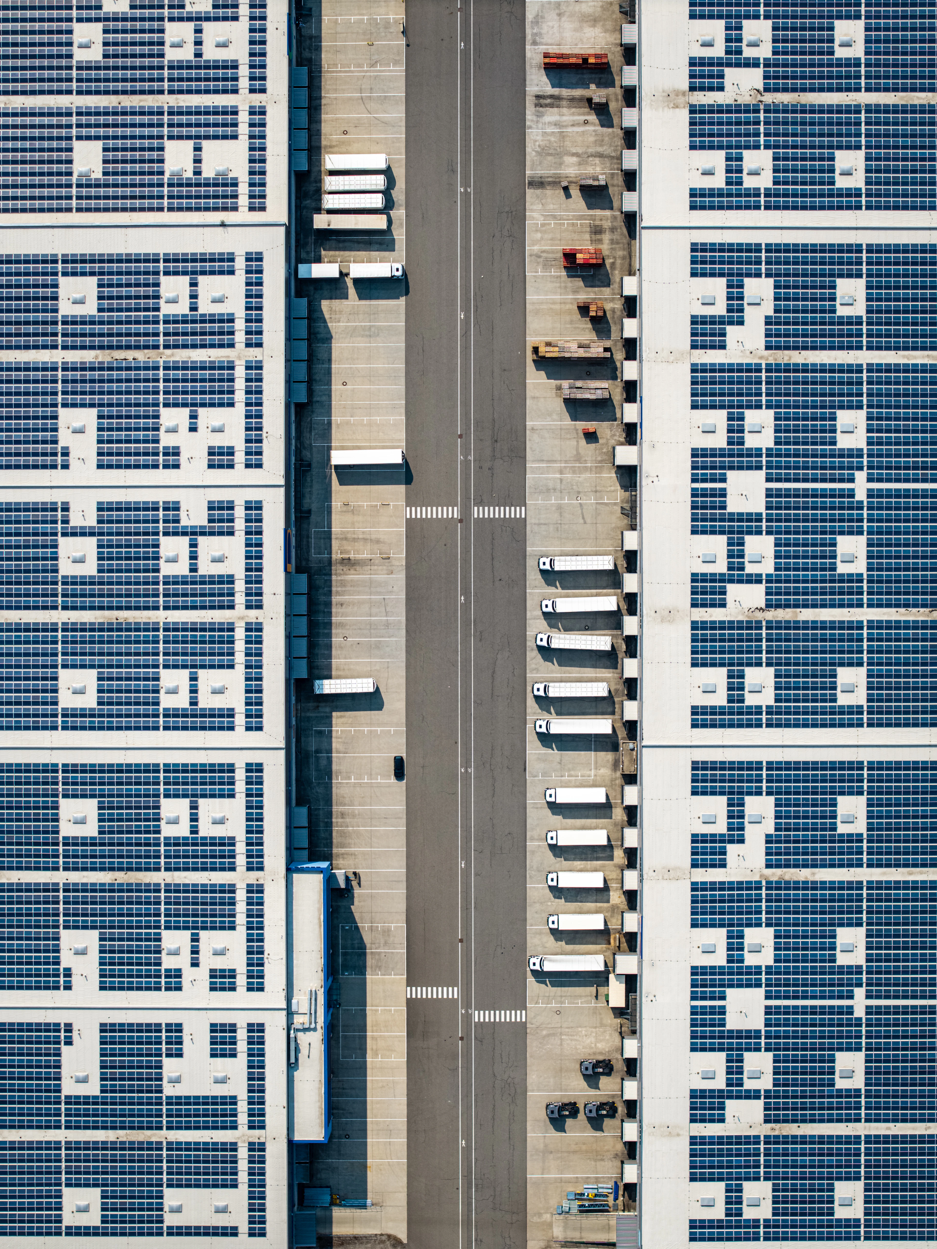 Imagen de referencia: almacén con paneles solares y camiones