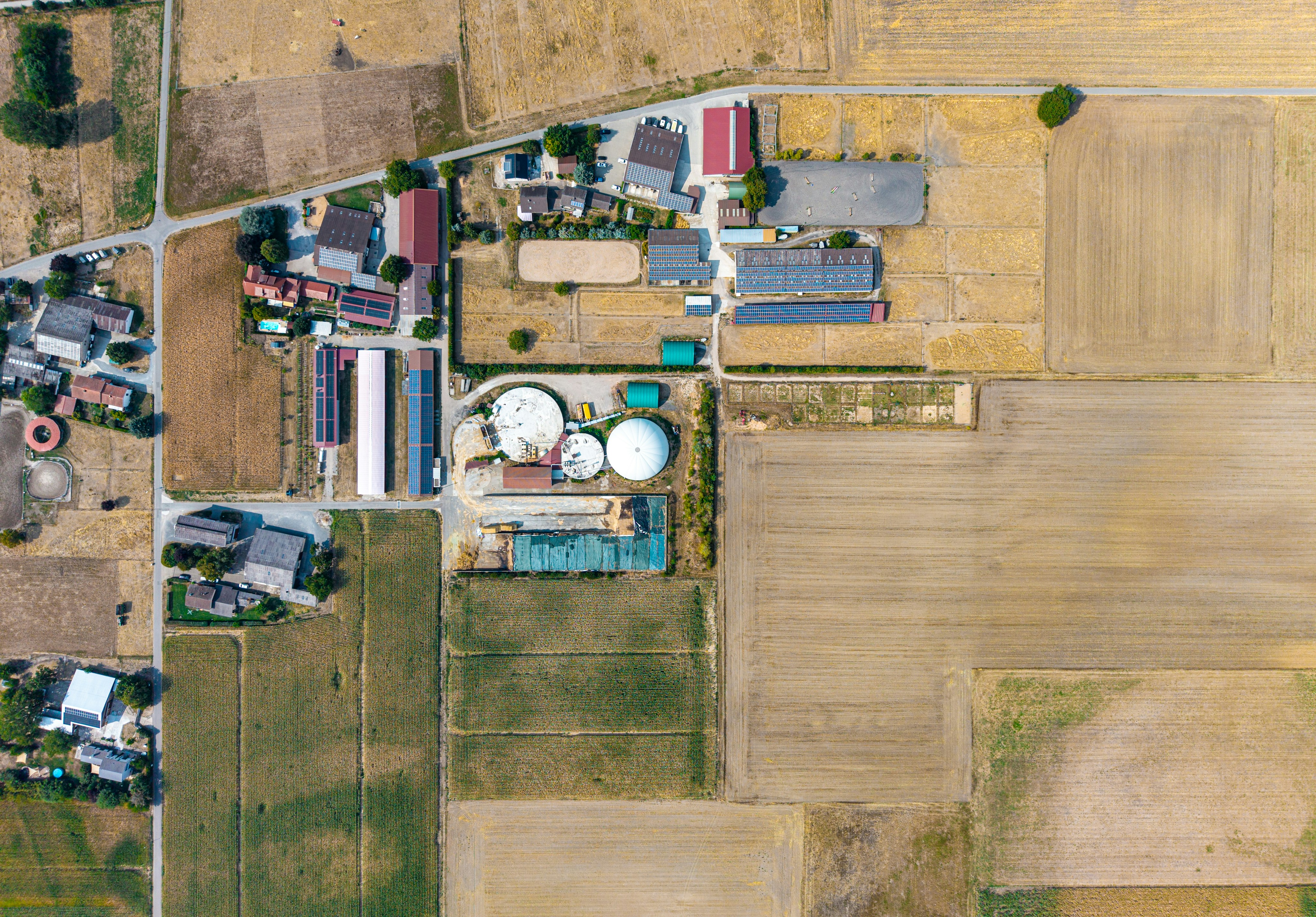 An aerial view of a farm complex with biogas digesters and surrounding fields