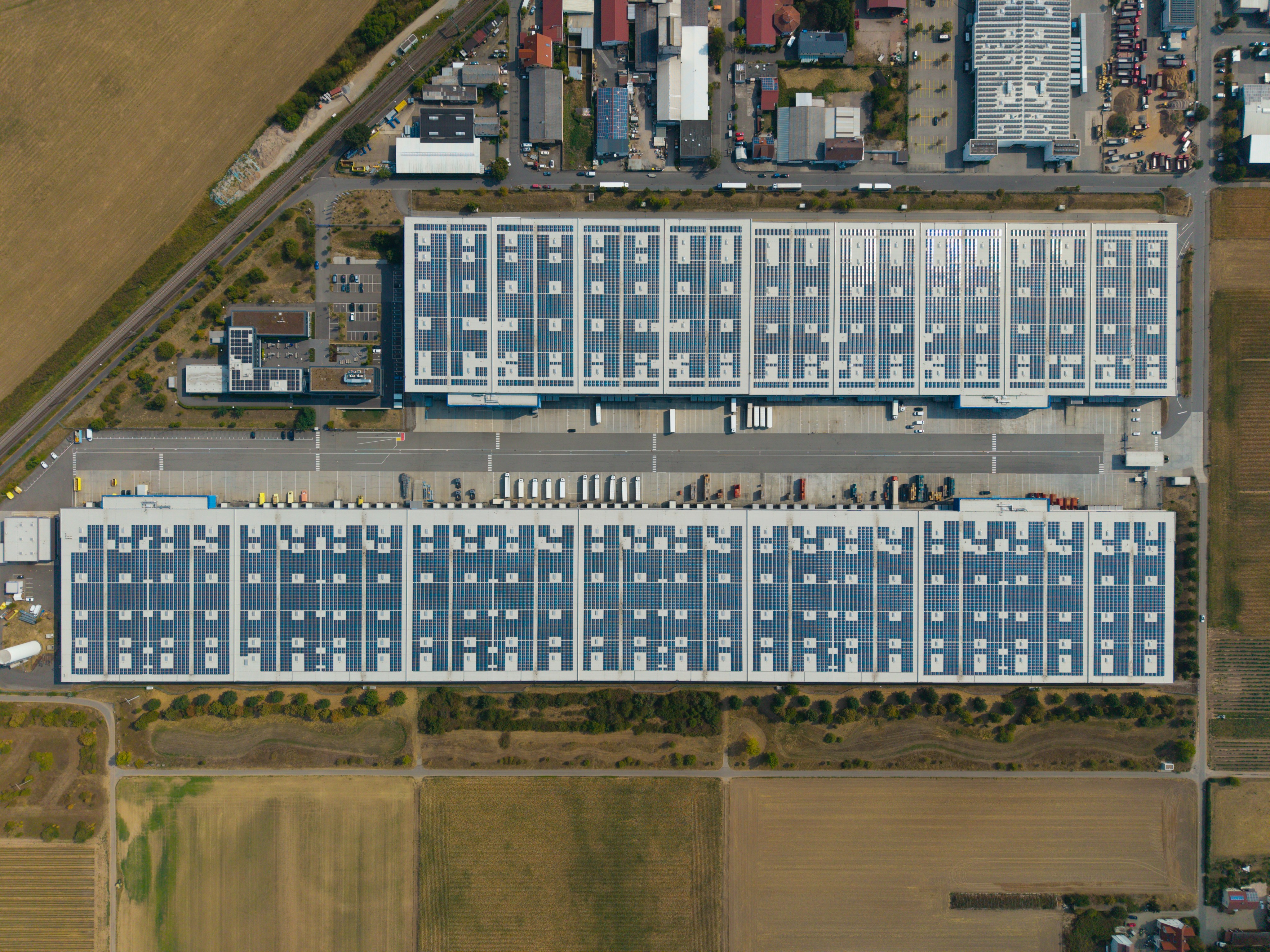 Aerial view of factory and warehouse roofs covered with solar panels