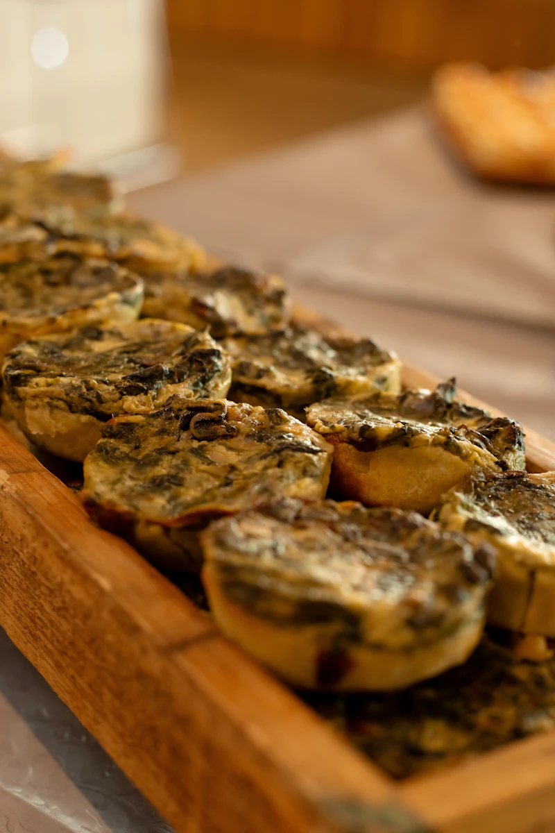 Small savoury breakfast tarts with herbs on a wooden tray