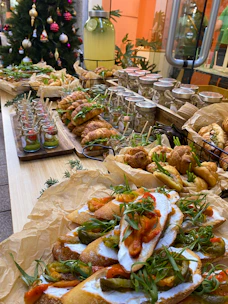 Assorted appetizers including crostini, croissants, and small jars on a wooden table
