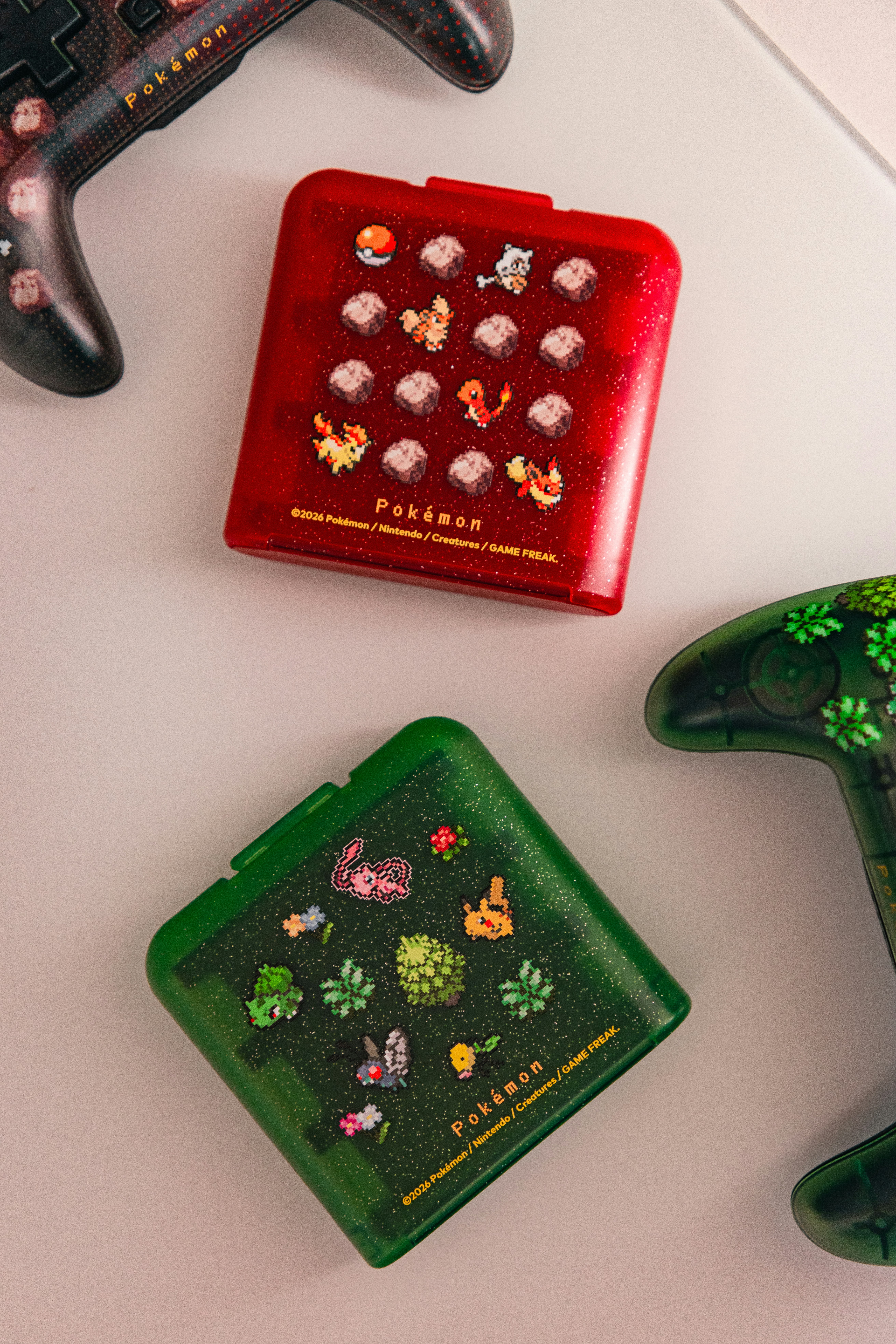 Two square game cases and two controllers on a light surface