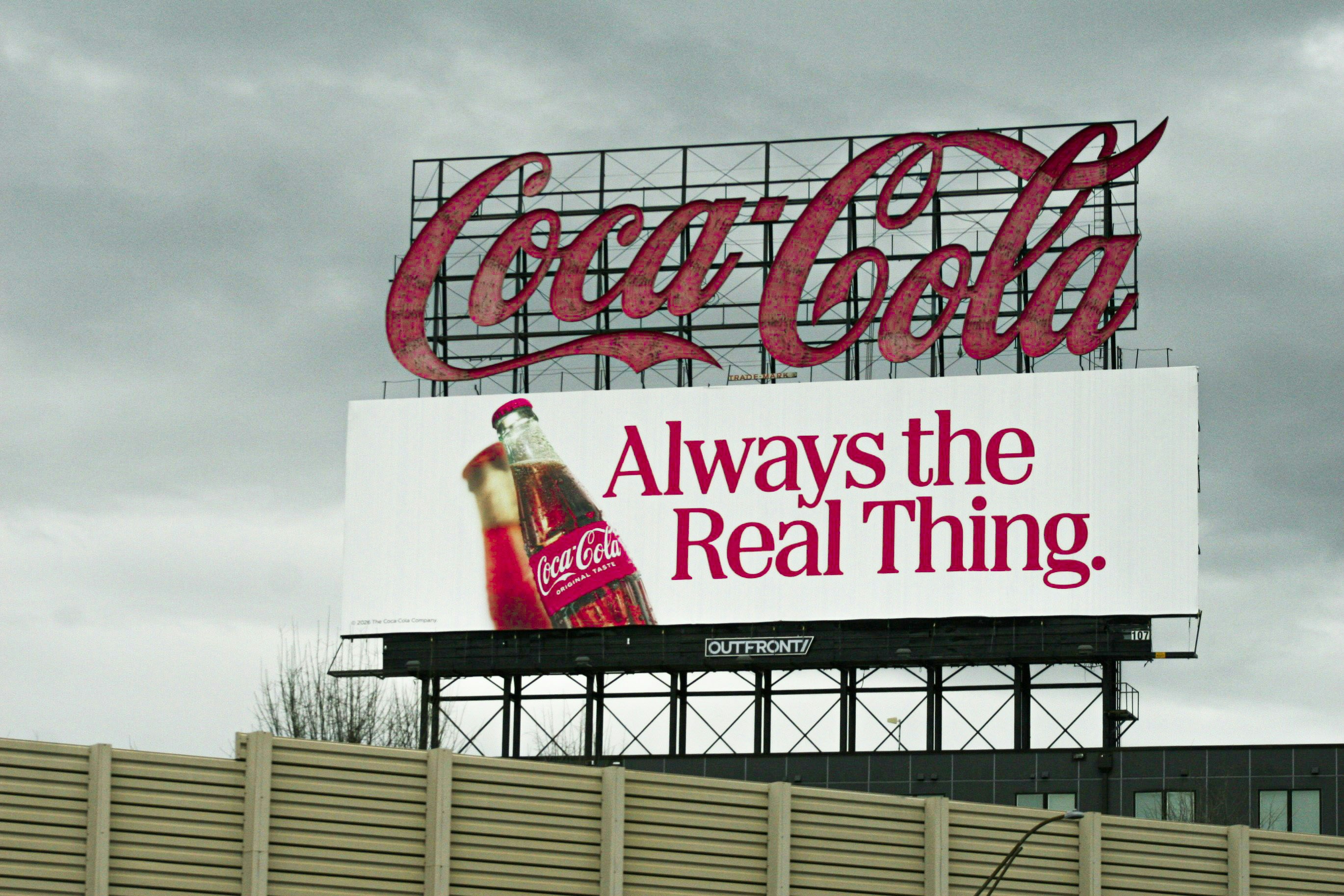 A Coca-Cola billboard with a bottle and text reading Always the Real Thing