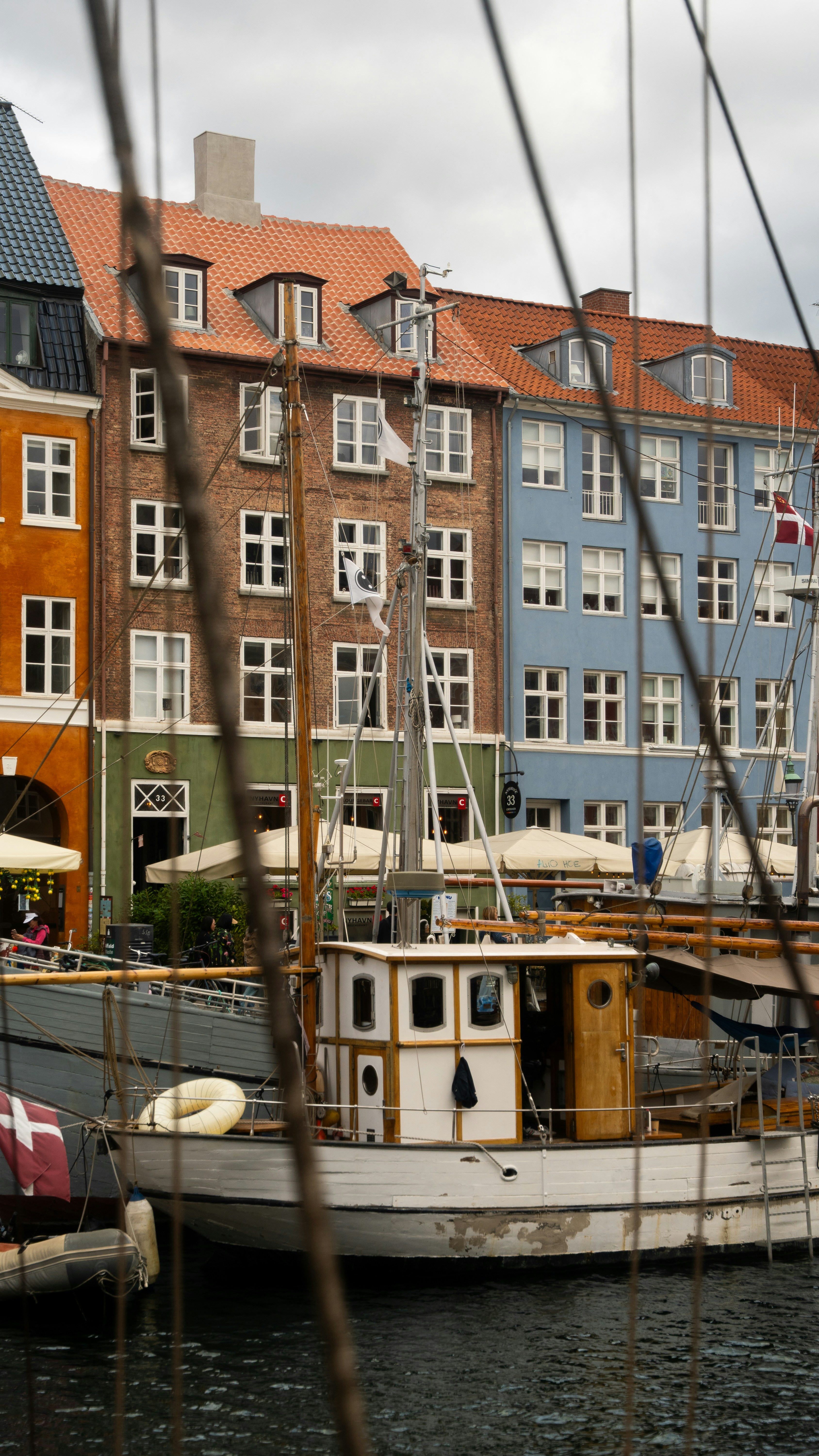 A white boat moored beside Copenhagen's colorful waterfront