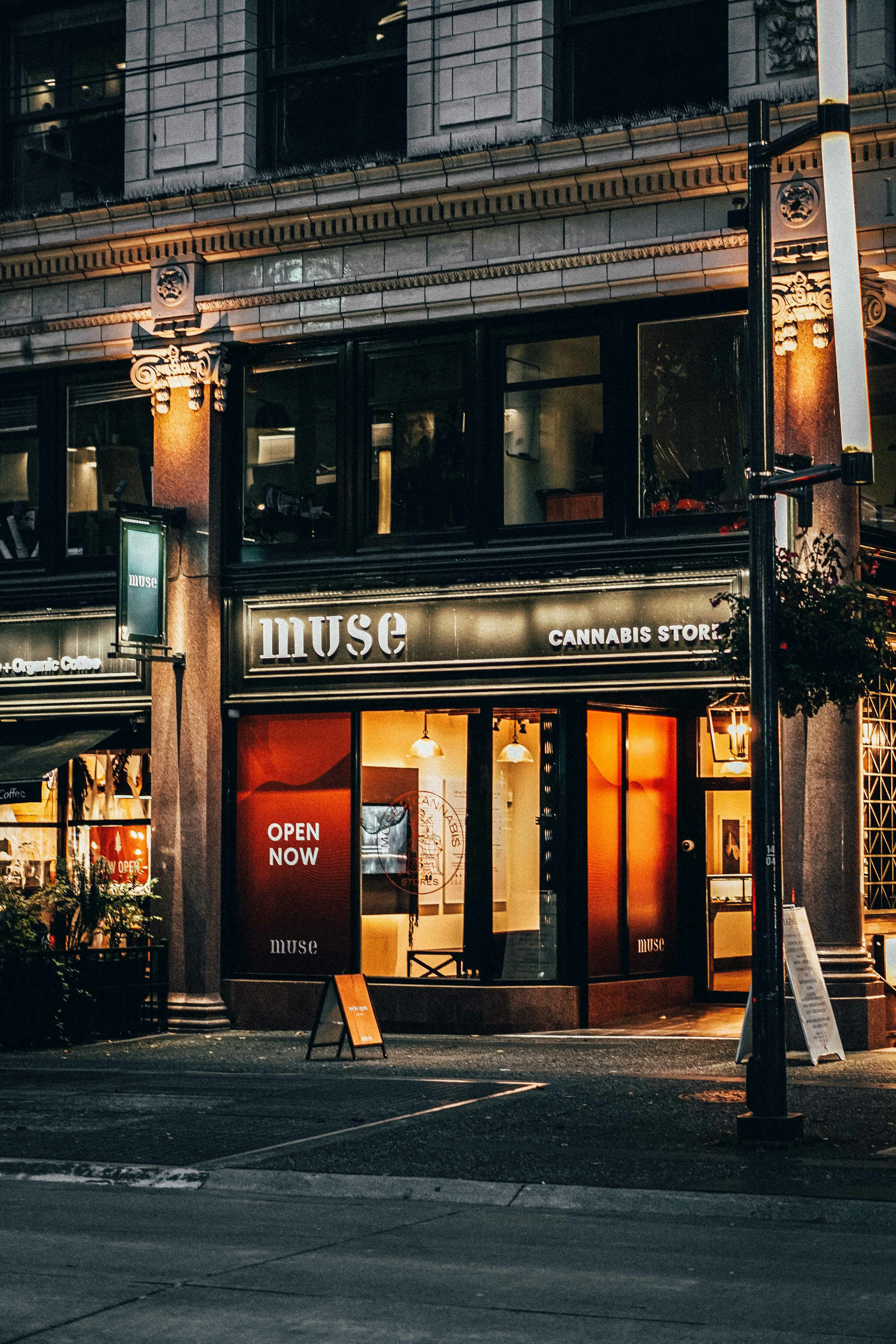 A storefront with a sign reading "muse" and "CANNABIS STORE" at night