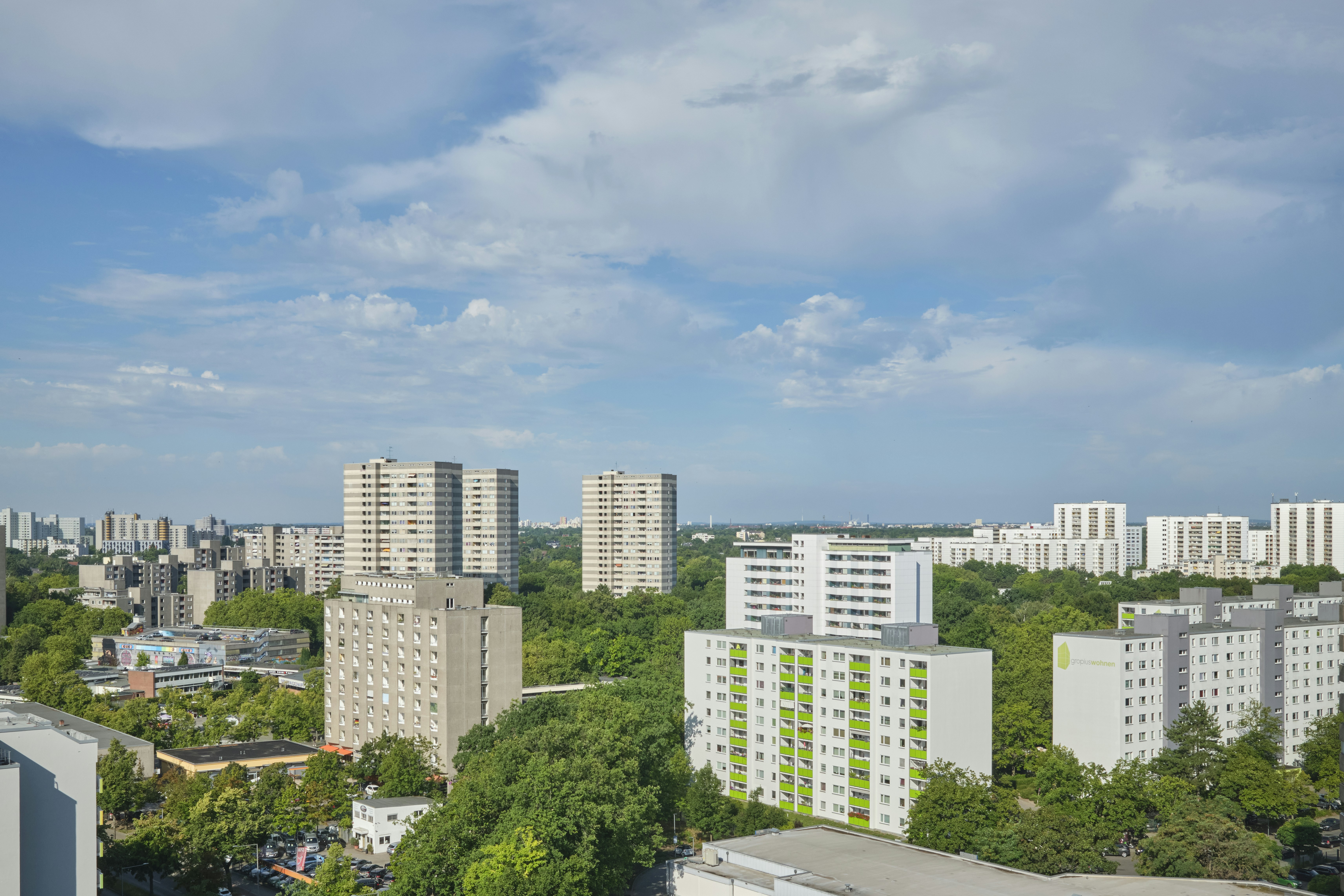 Hochhäuser, umgeben von dichten grünen Bäumen unter blauem Himmel