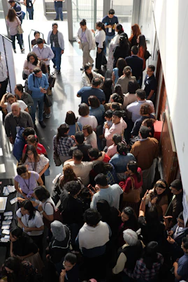 A large group of people standing in a long queue inside a building