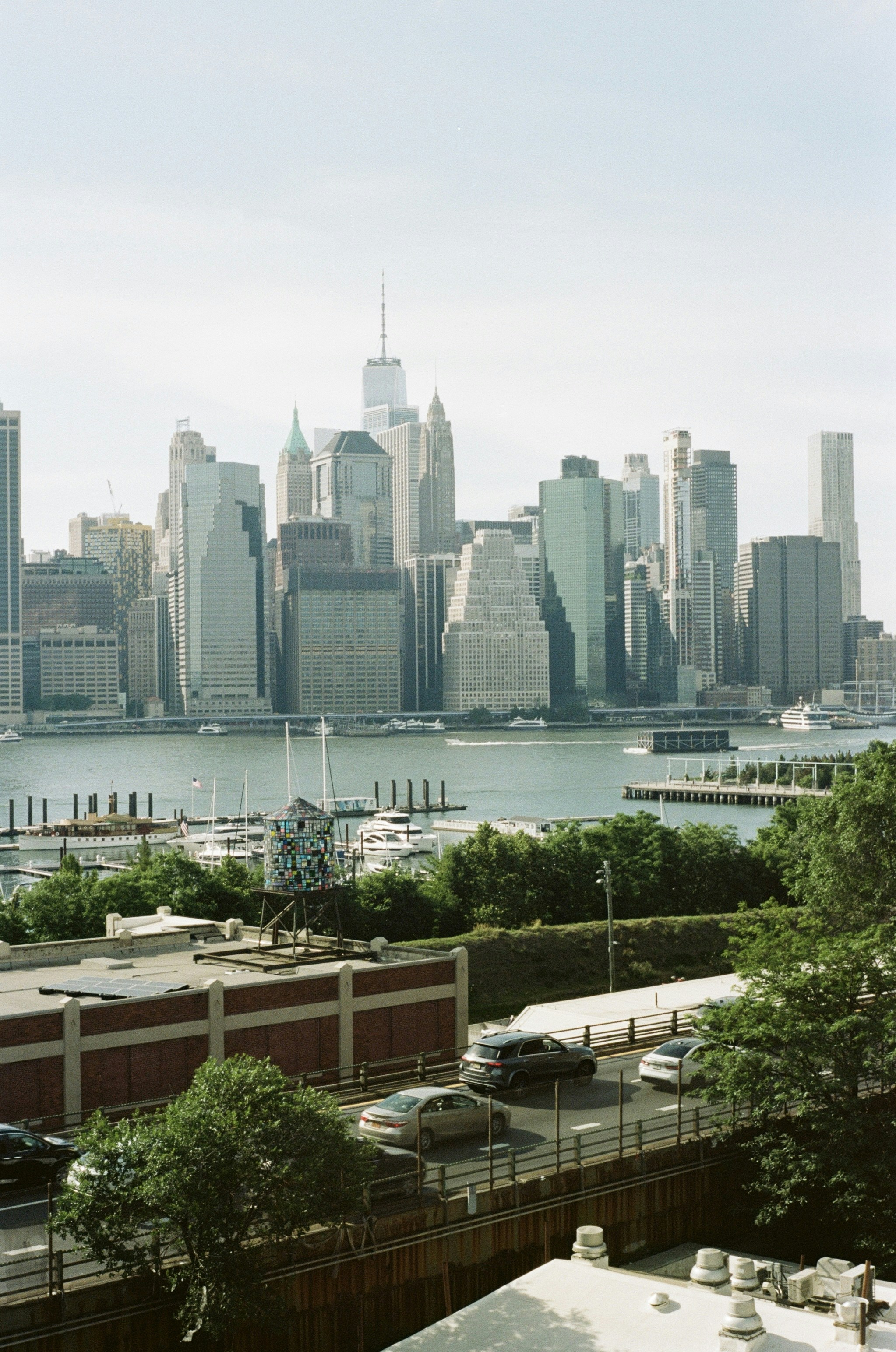 The Manhattan skyline across the East River with a mosaic water tower in foreground