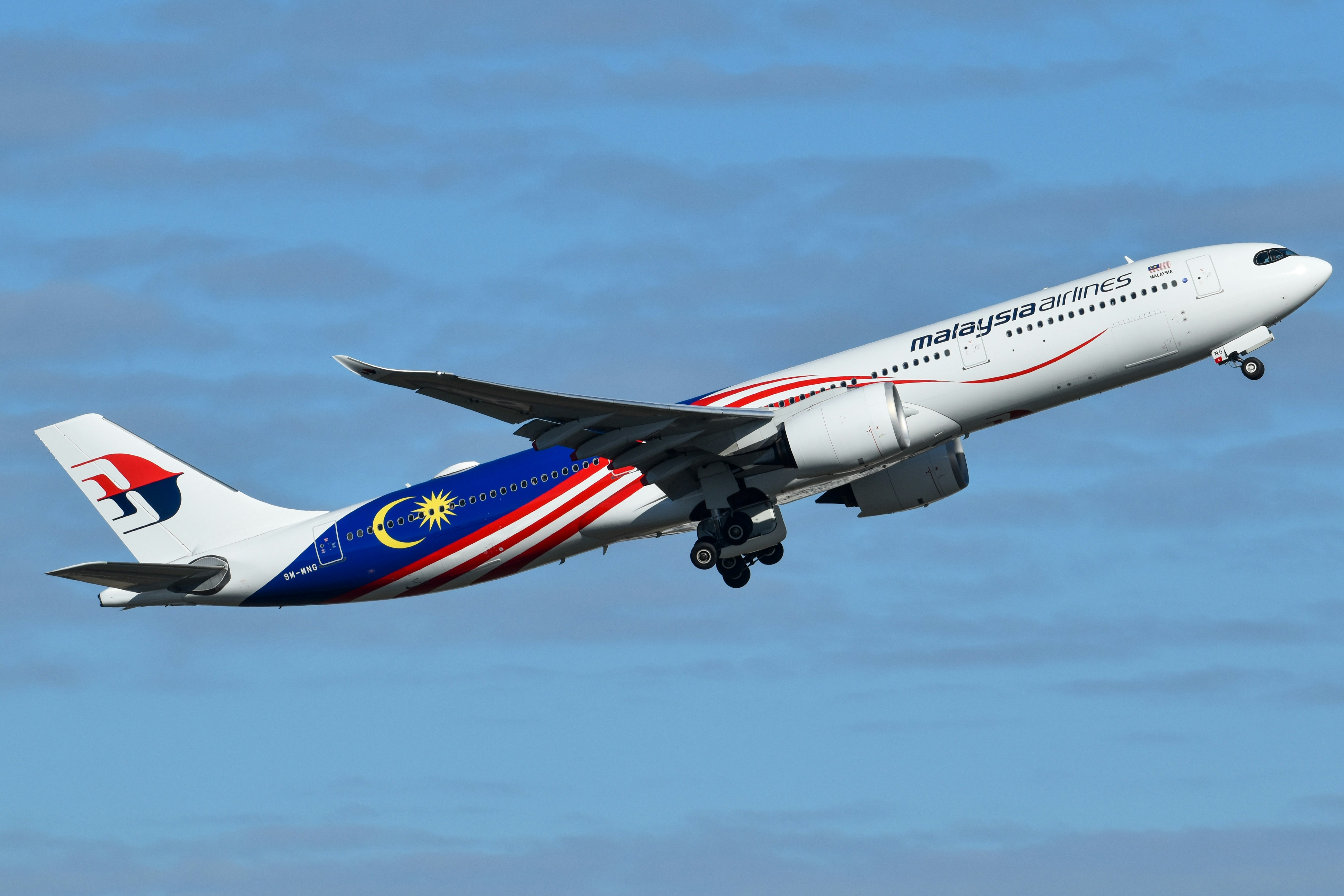 A Malaysia Airlines passenger jet climbing into a clear blue sky