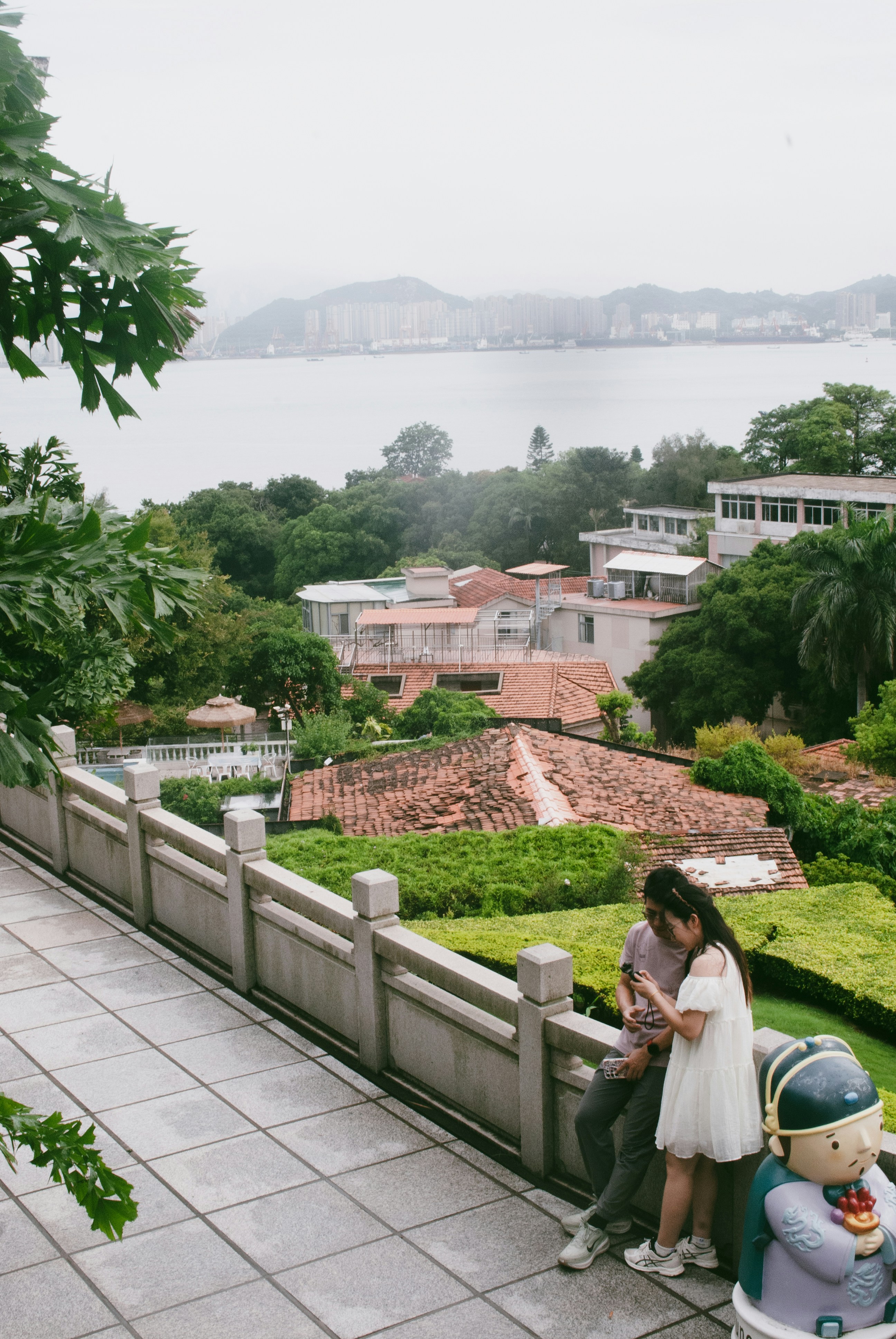 A man and a woman looking at a phone on a stone terrace