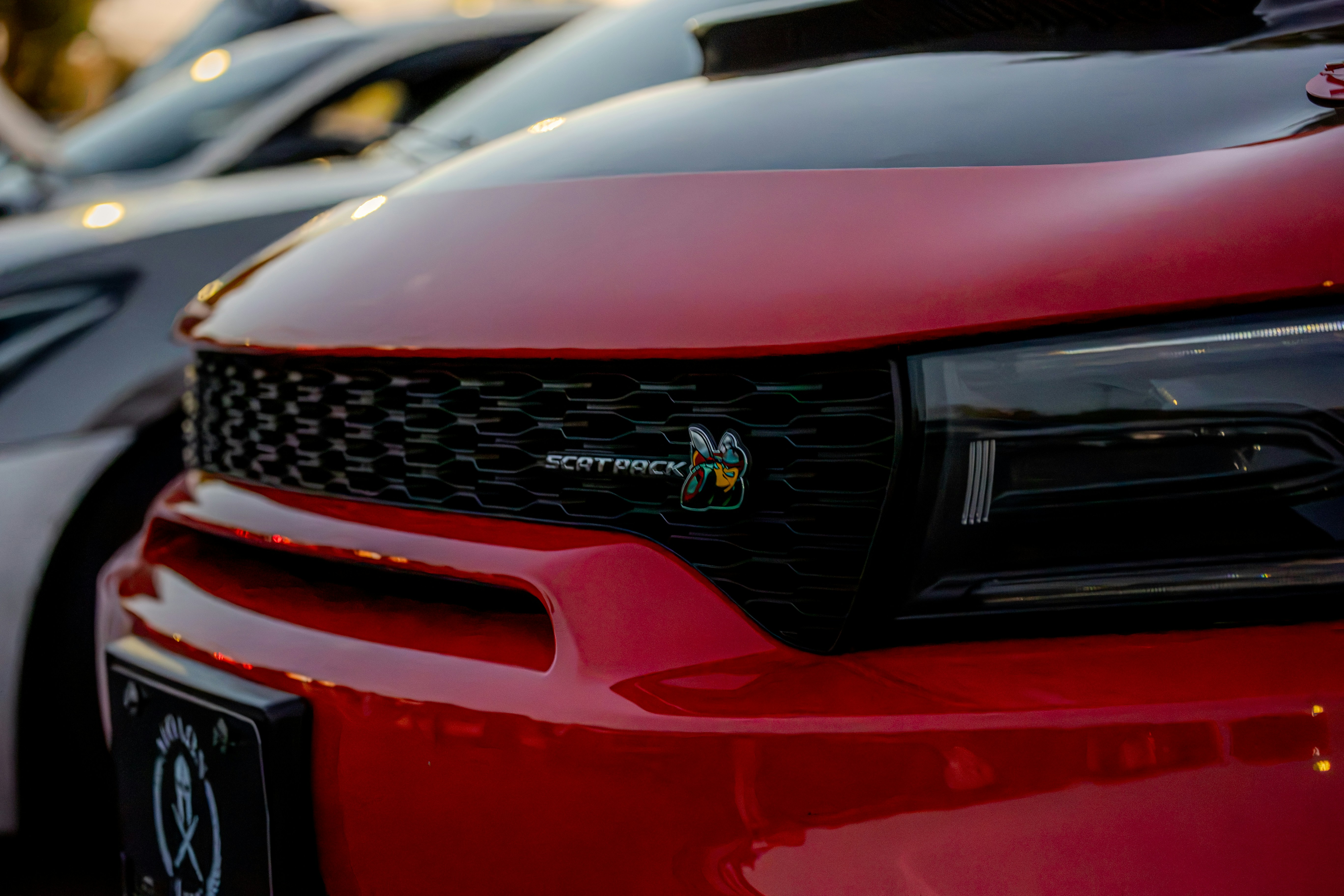 A red car front grille with a Scat Pack bee emblem