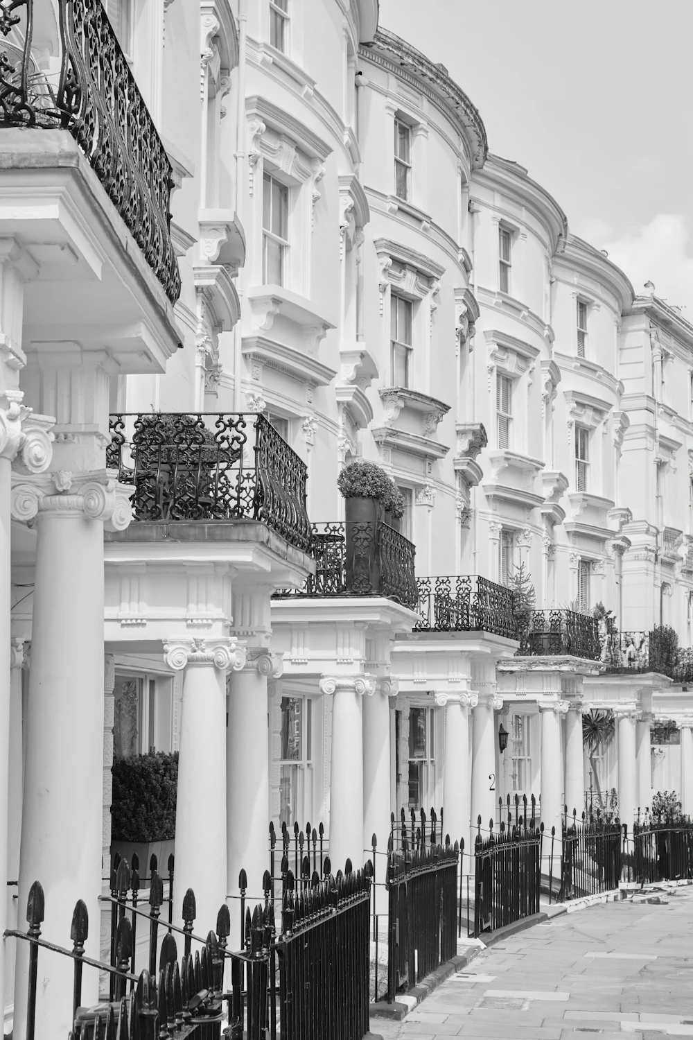 A row of white Victorian townhouses with black iron balconies