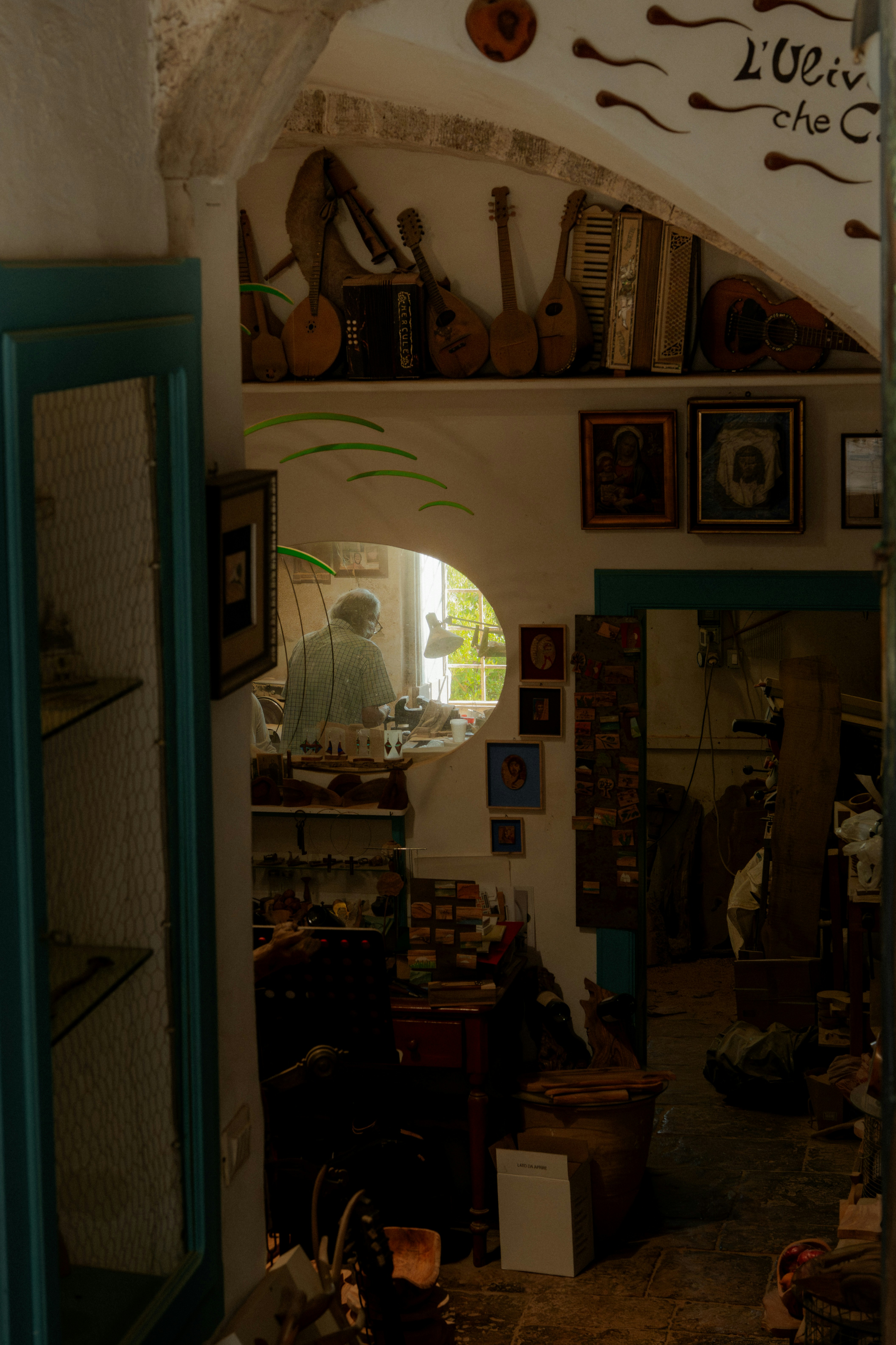 A person working at a desk seen through a circular window in a workshop