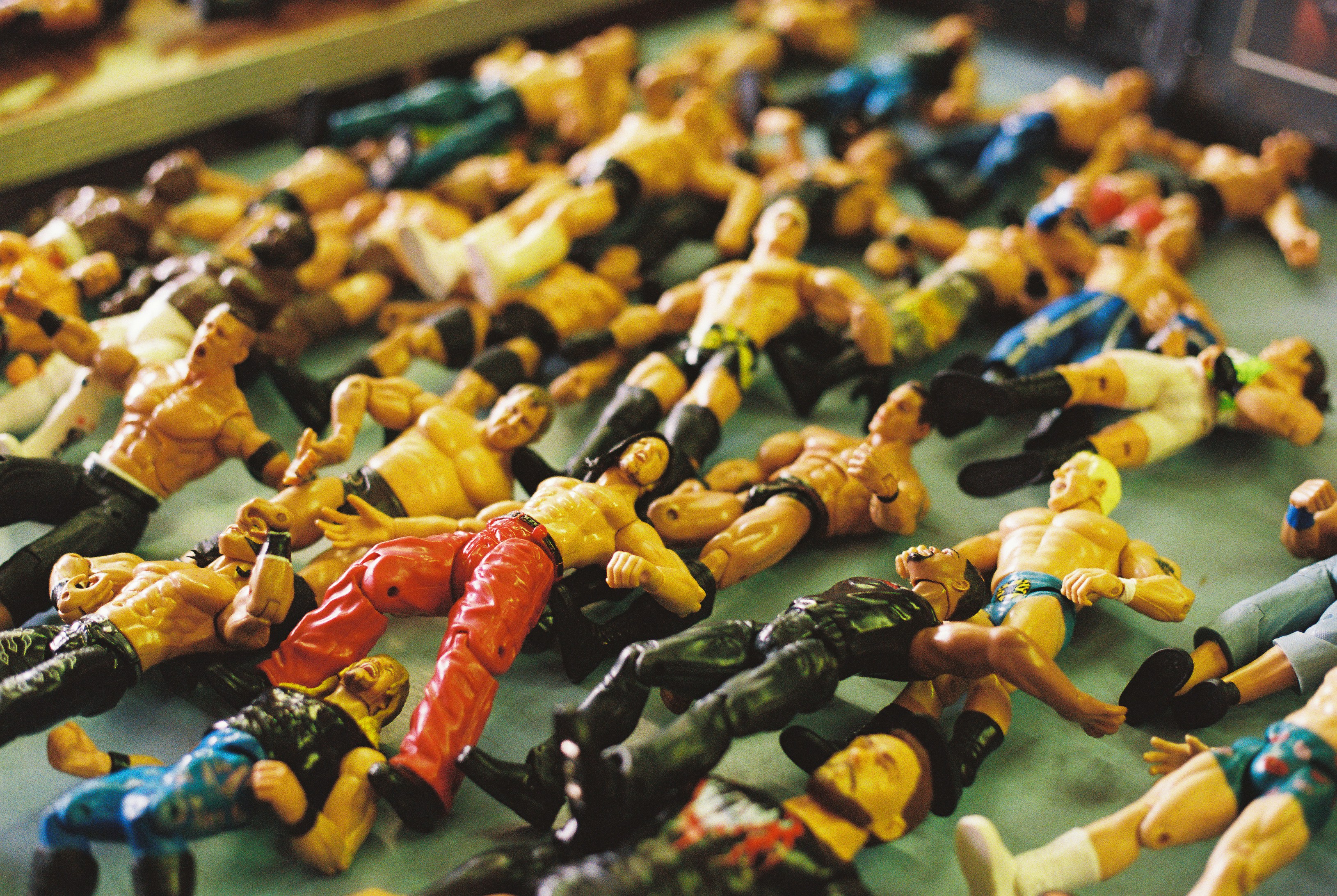 A large group of plastic wrestling action figures scattered on a flat surface