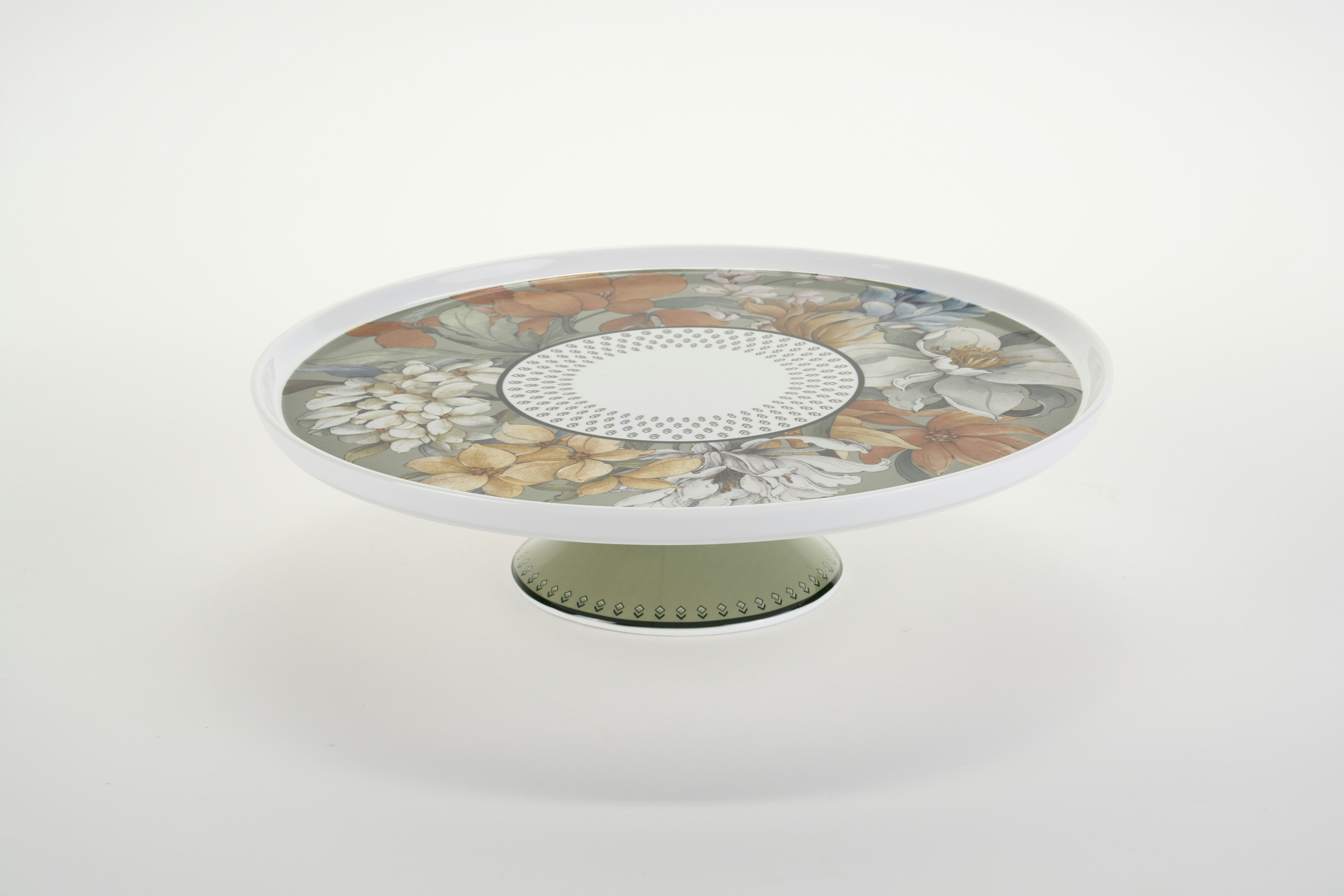 A ceramic cake stand with a floral pattern on a white background