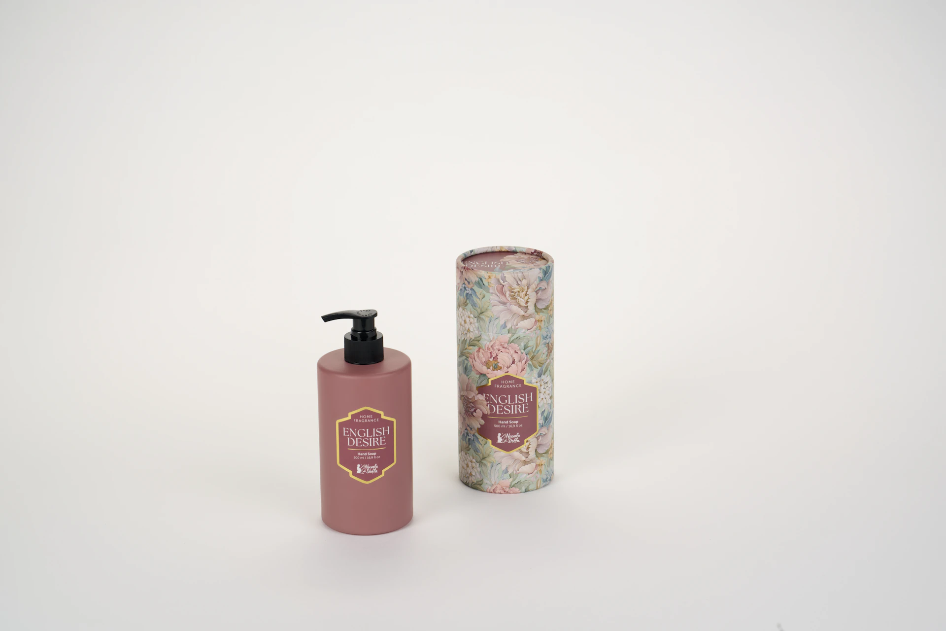 A pink hand soap pump bottle beside a floral patterned cylindrical gift box
