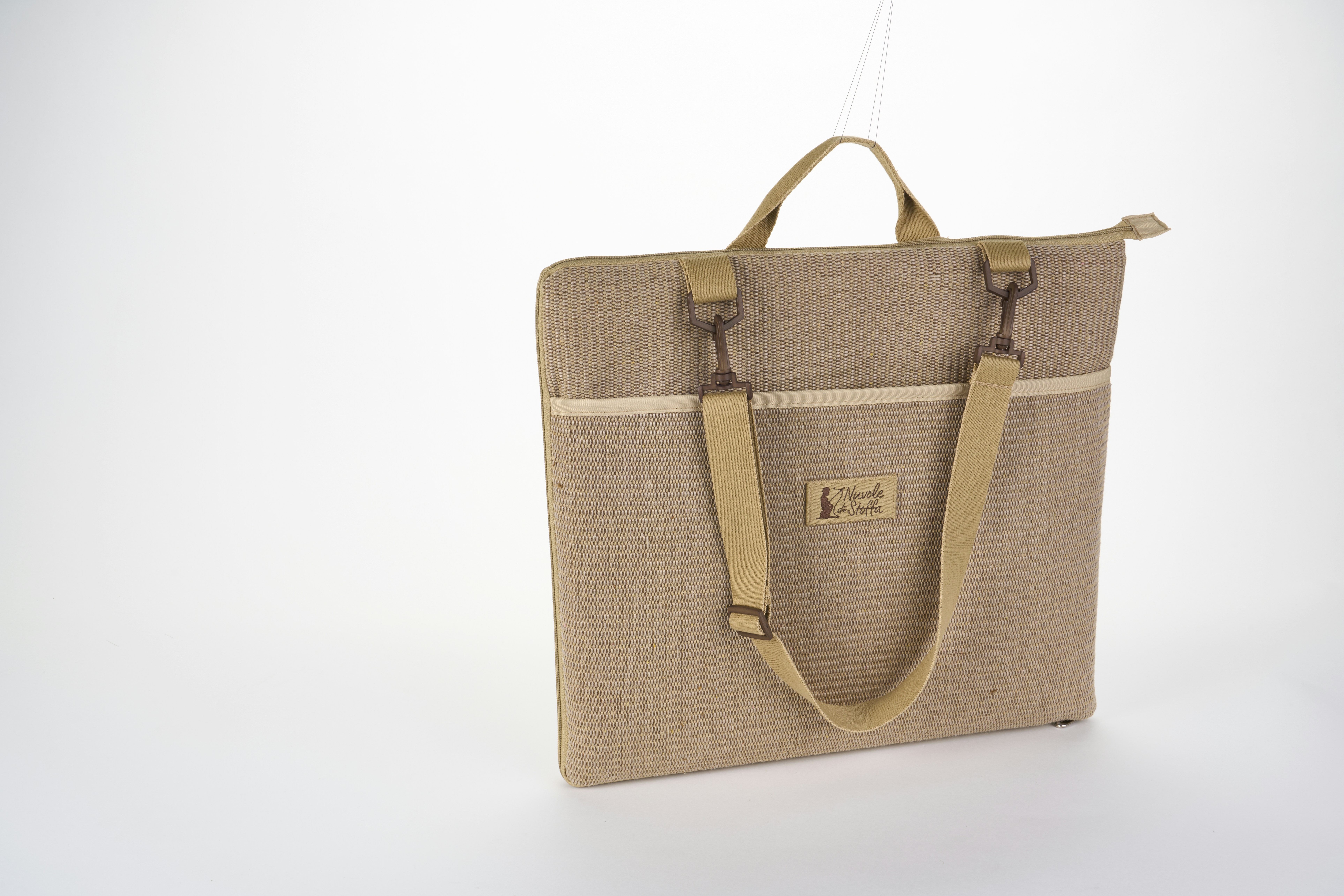 A tan woven fabric tote bag with shoulder straps on a white background