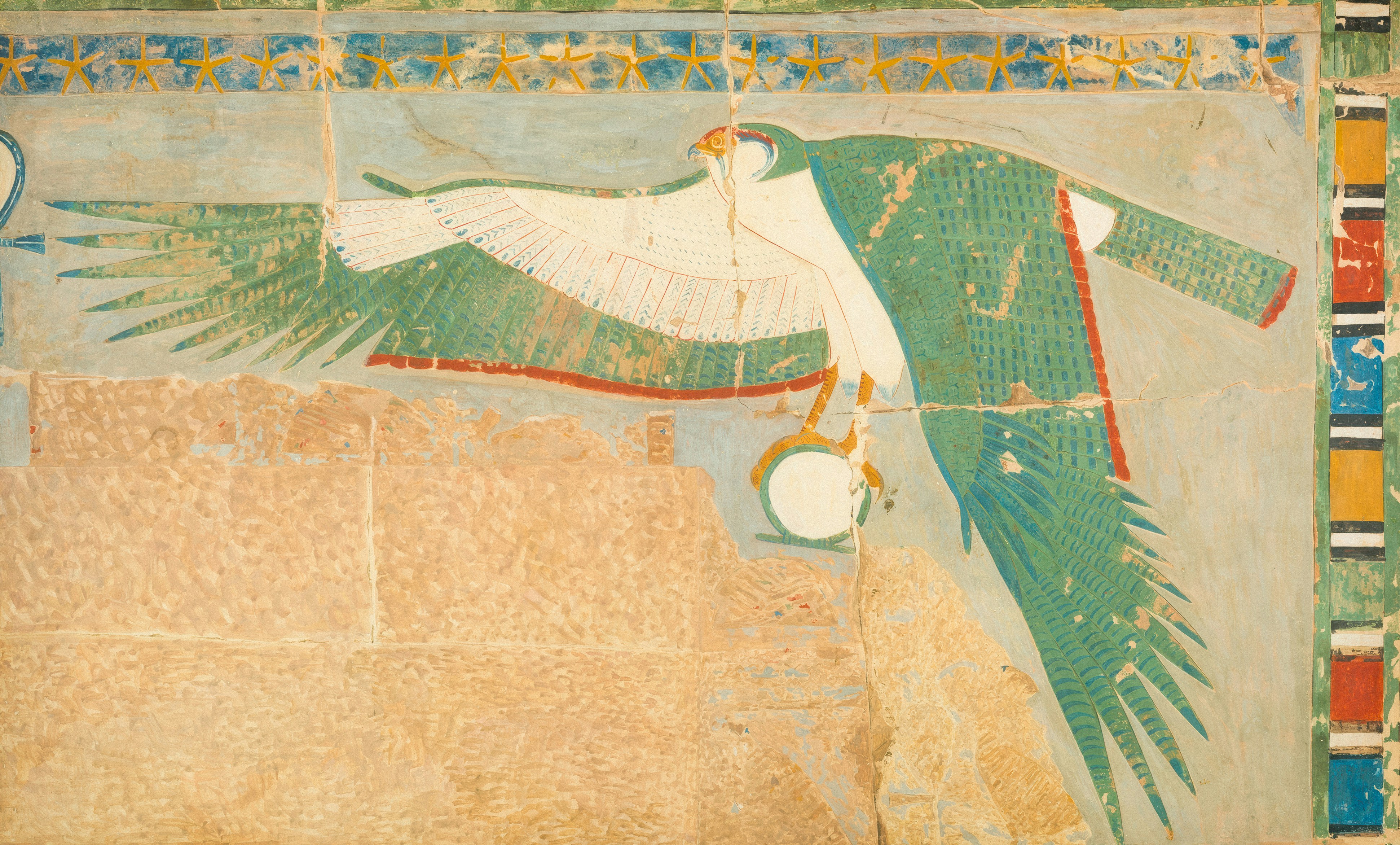 An ancient Egyptian wall painting of a falcon with outstretched wings holding a shen ring