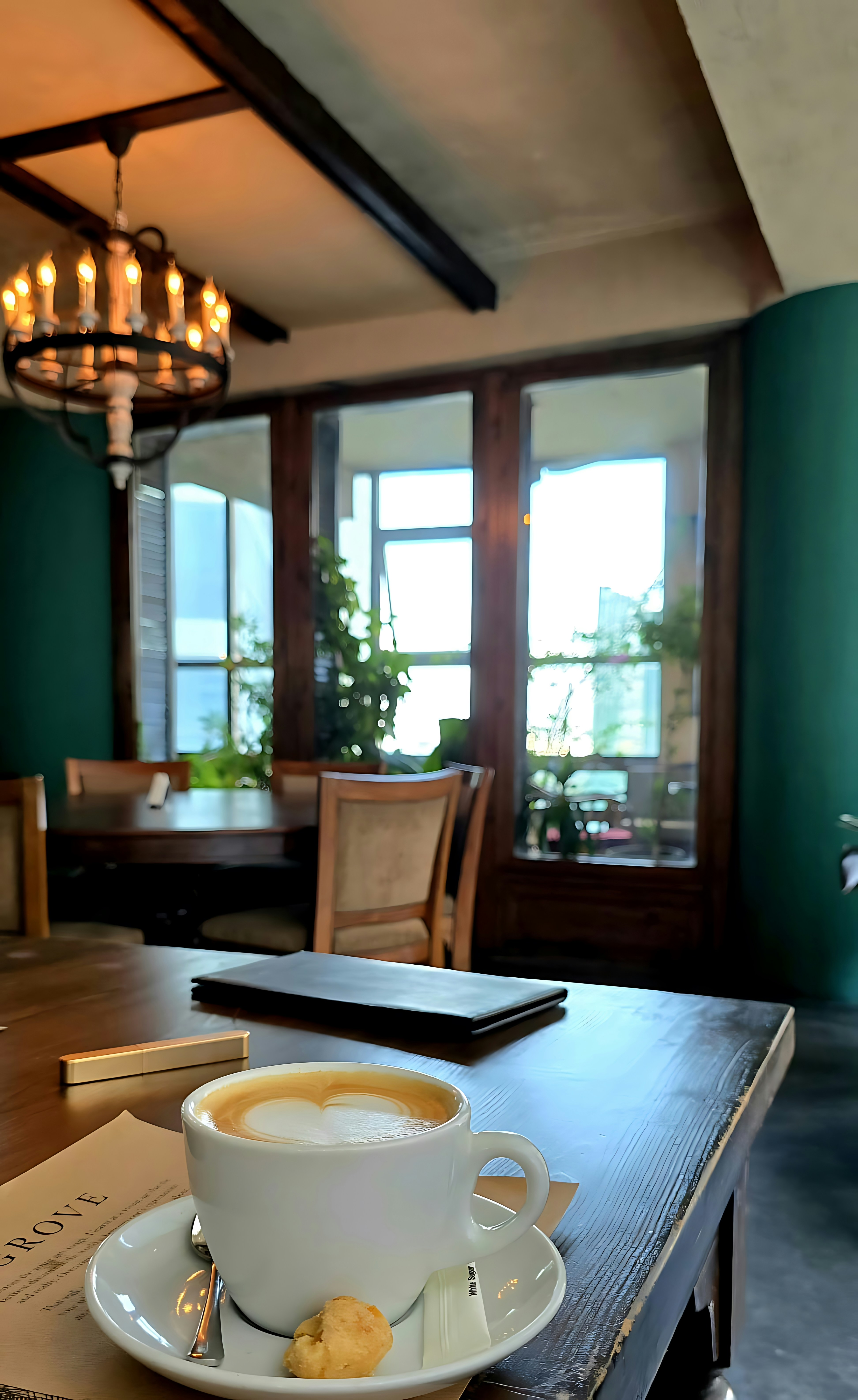 A cup of coffee with latte art on a wooden table in a cafe