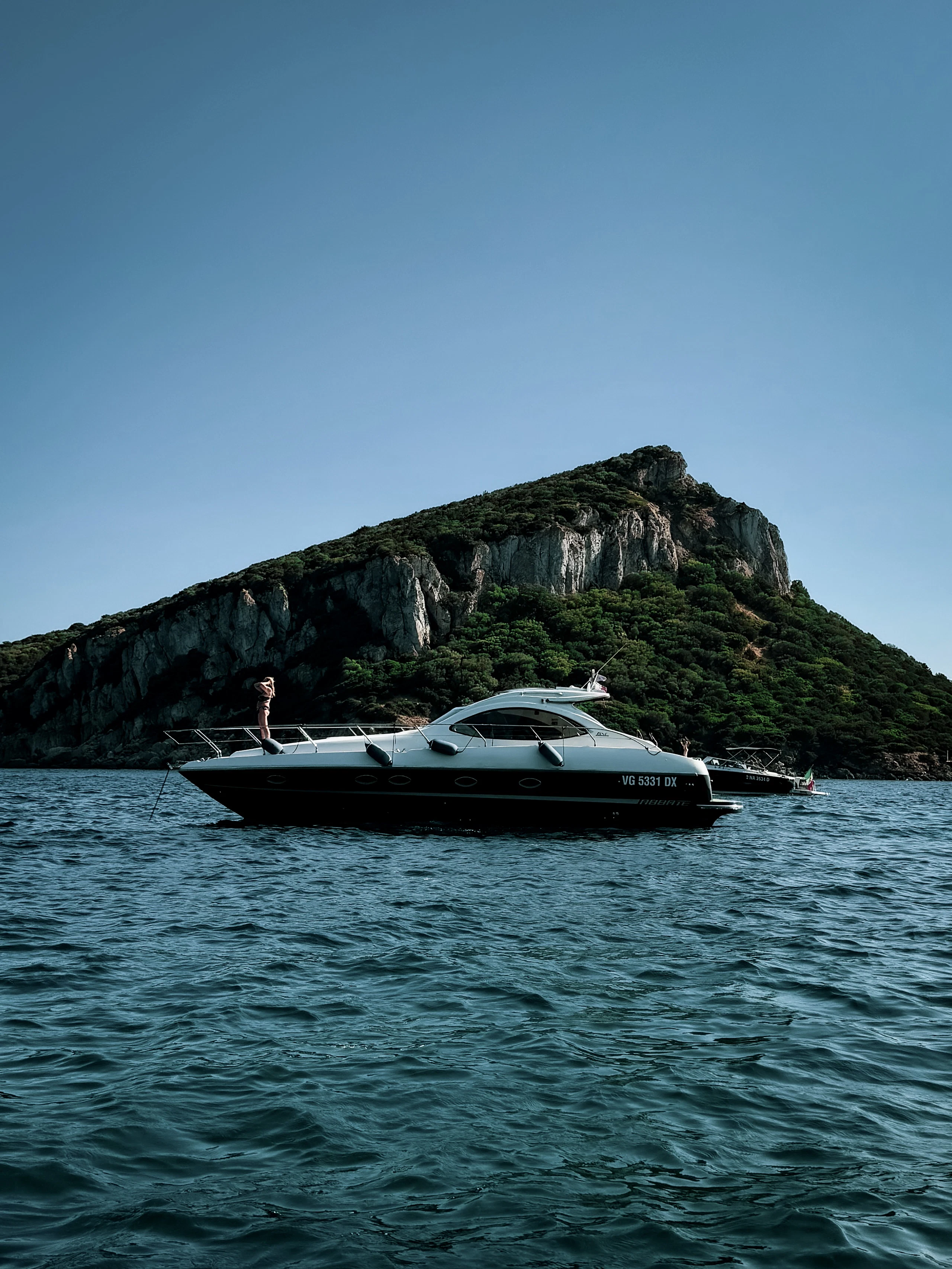 White motorboat near a rocky island