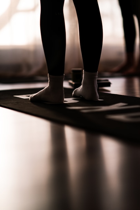Close-up of a person's socked feet standing on a black exercise mat