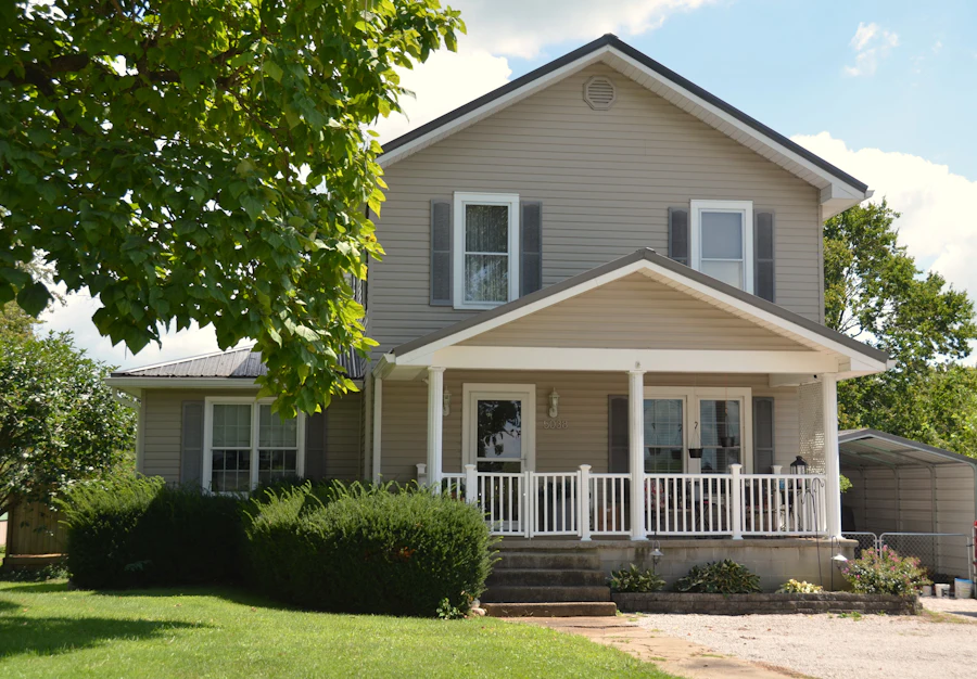 Two-story house with beige siding and a white porch