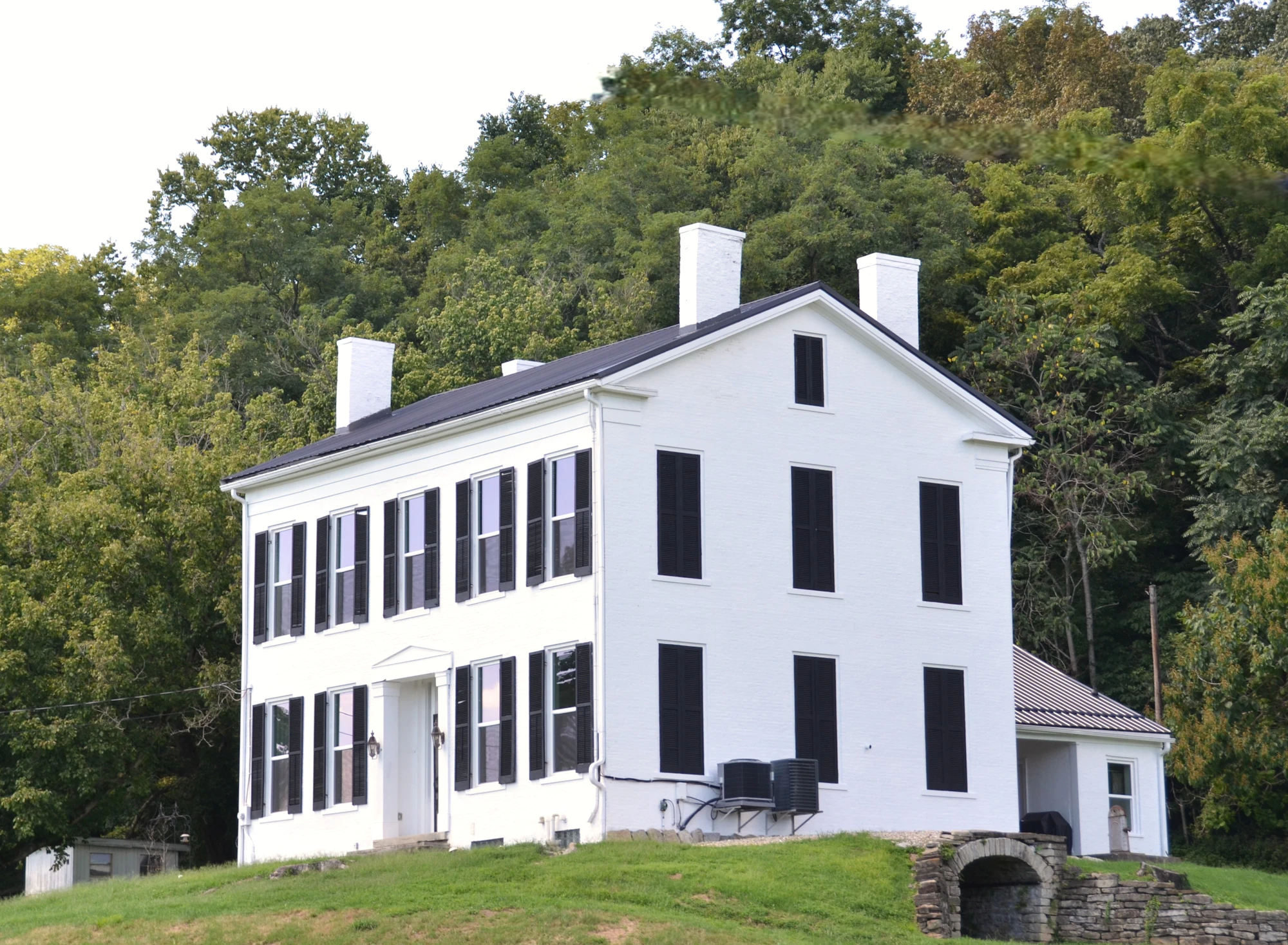 A historic white house with black shutters