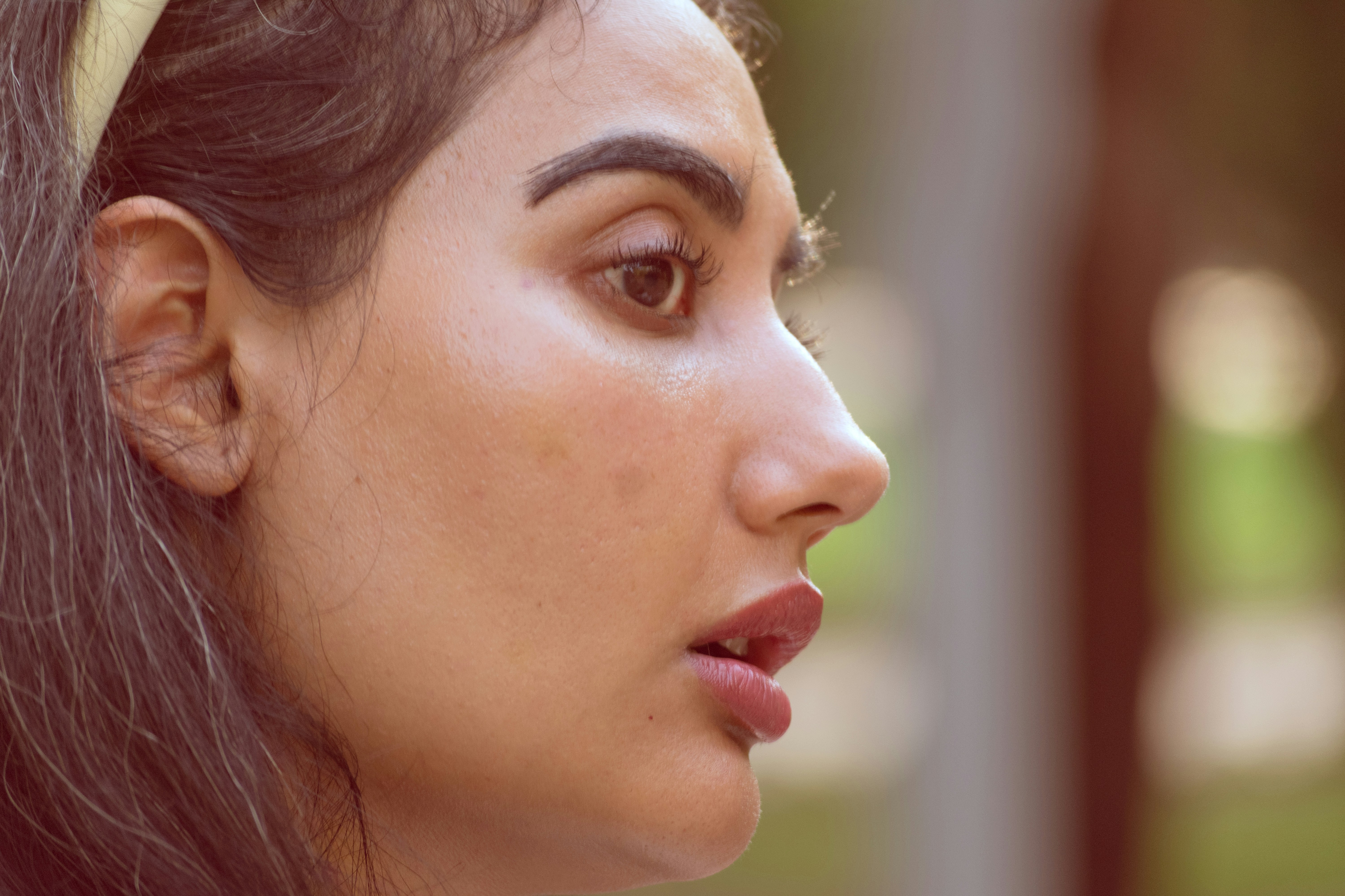 Profile view of a woman with dark hair and lips in soft light