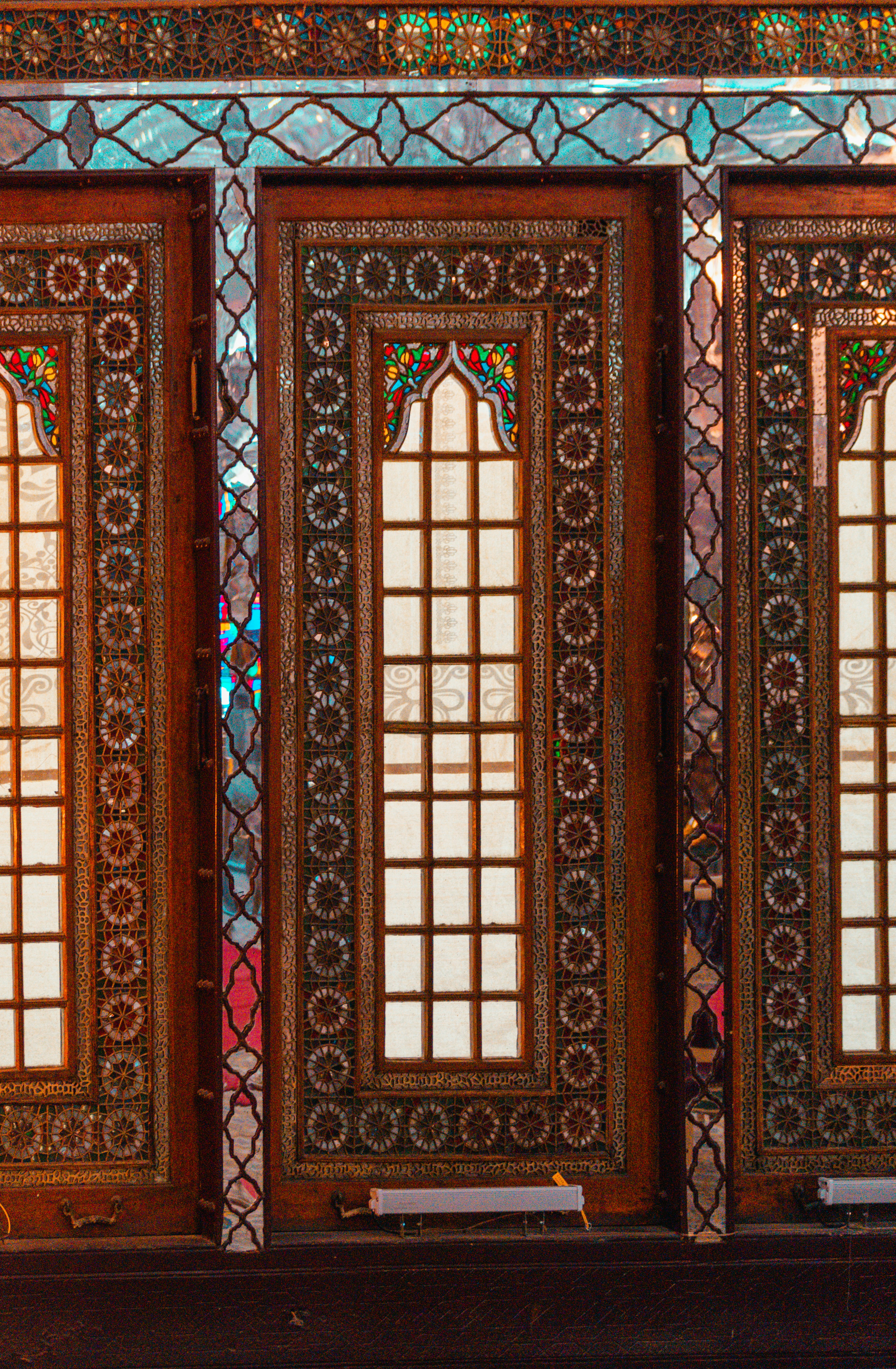 Intricate wooden panels with stained glass and mirror mosaic inlays
