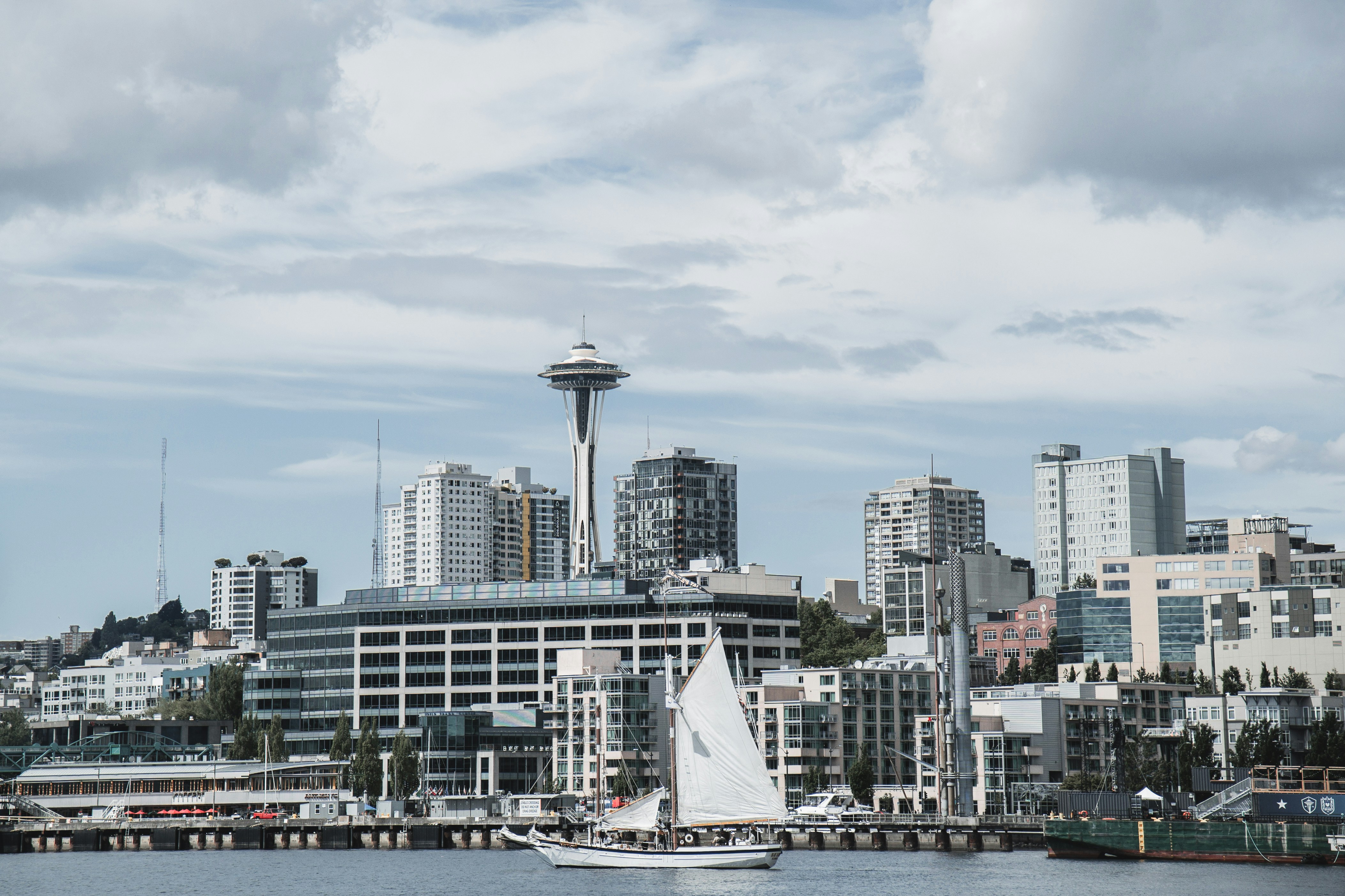 A sailboat on the water before the Space Needle and Seattle skyline